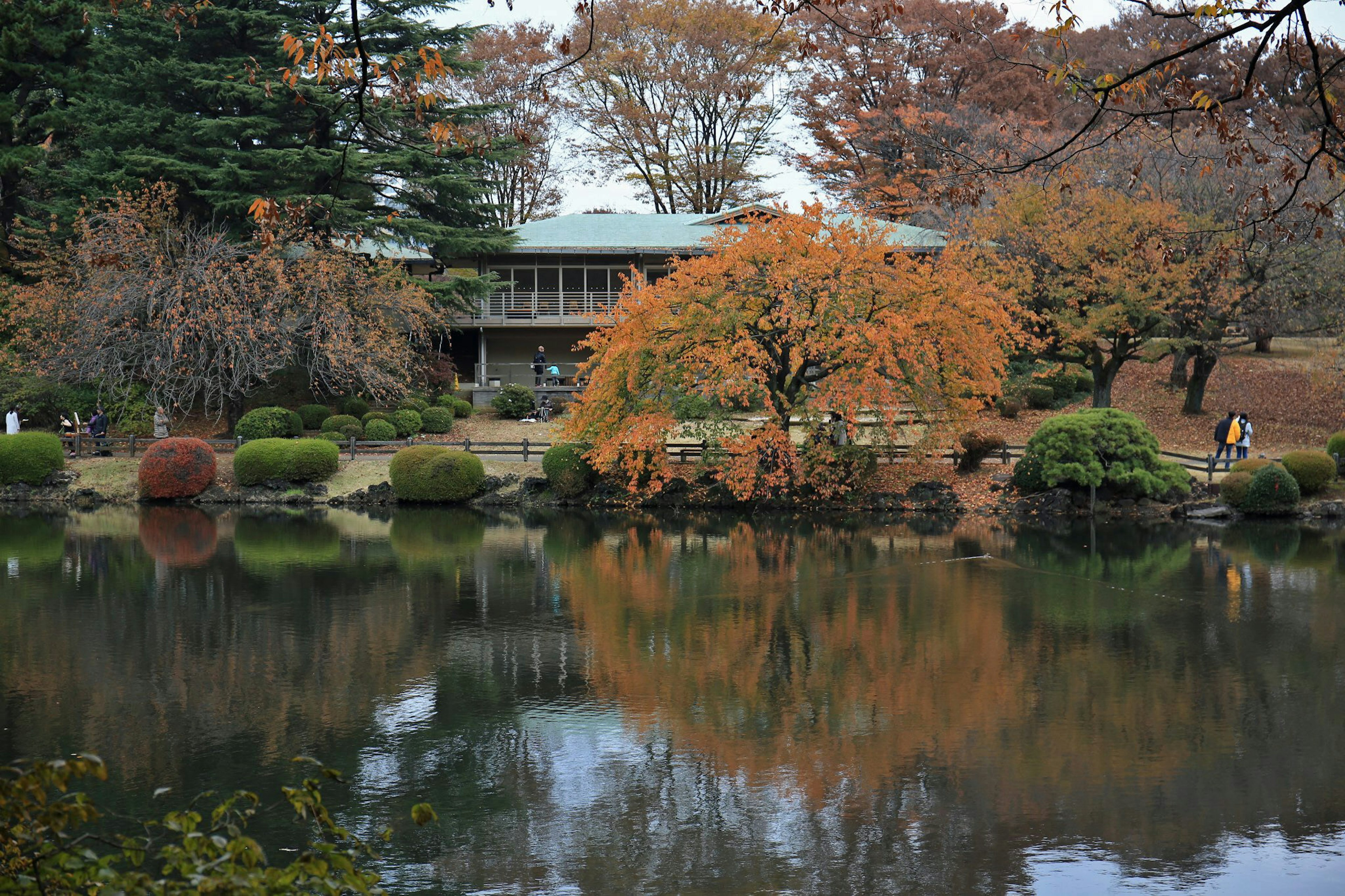 Étang serein reflétant le feuillage d'automne et un bâtiment traditionnel