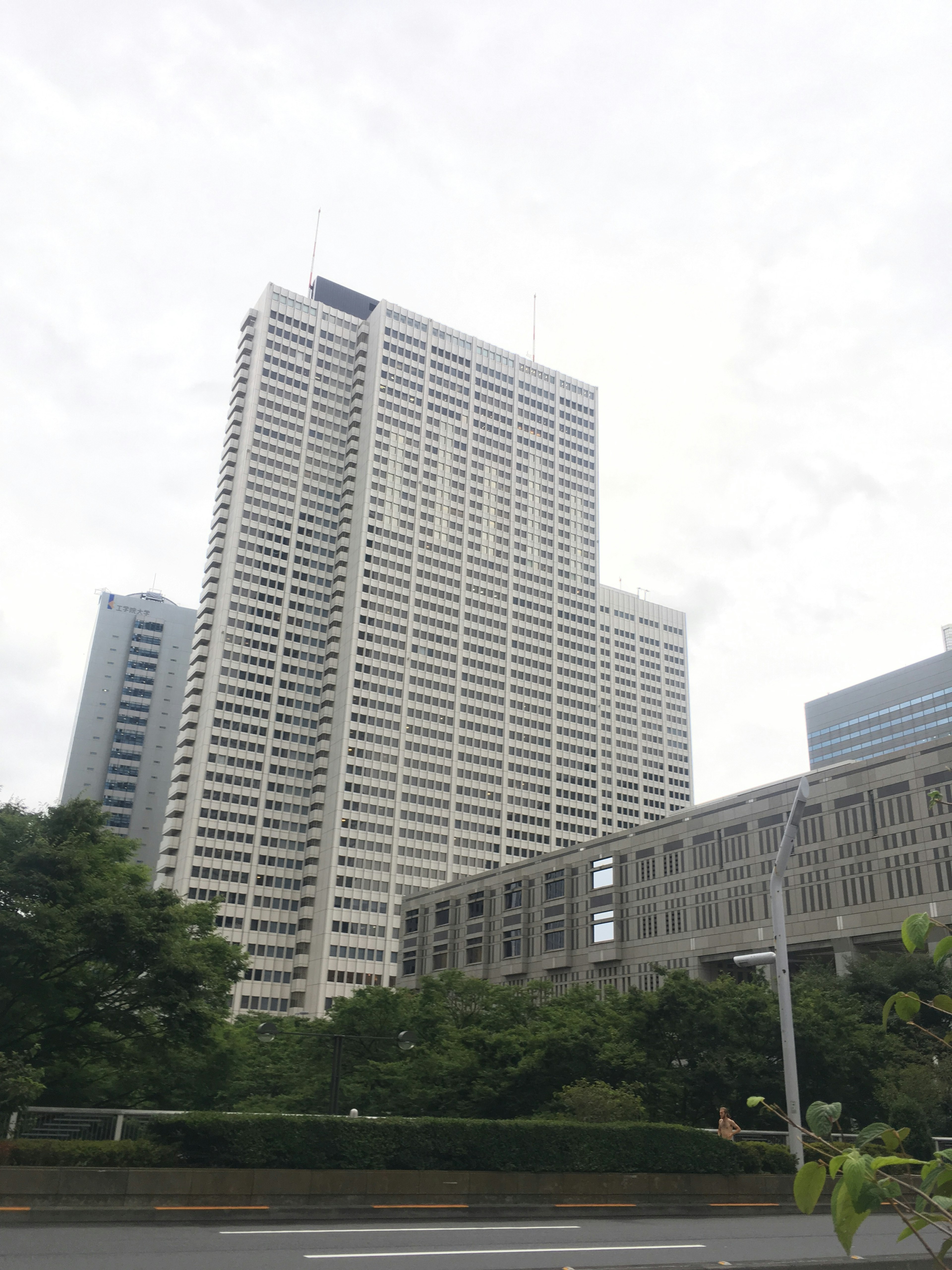 Urban landscape featuring a tall building surrounded by greenery