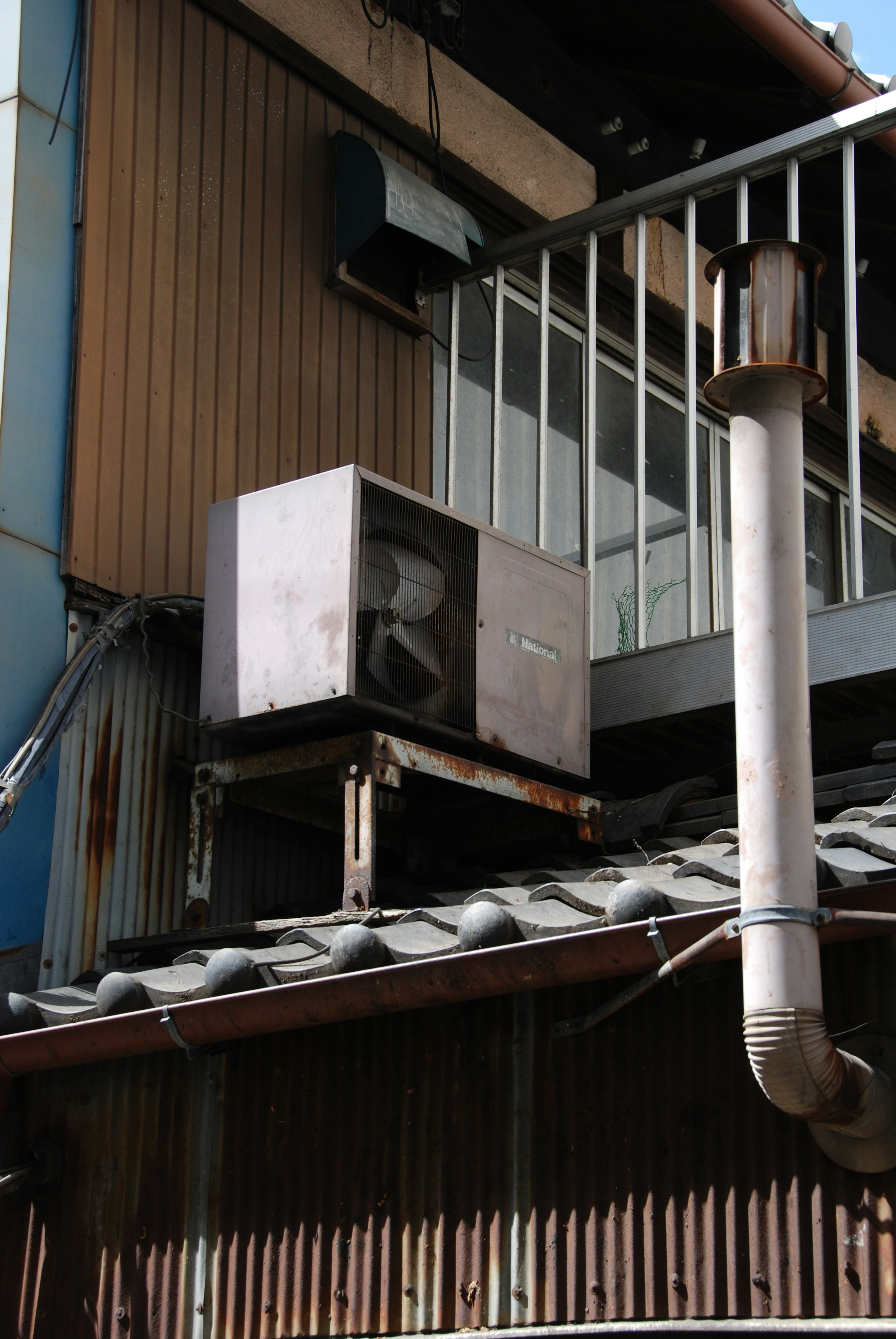 Air conditioning unit and chimney on the roof of an old building