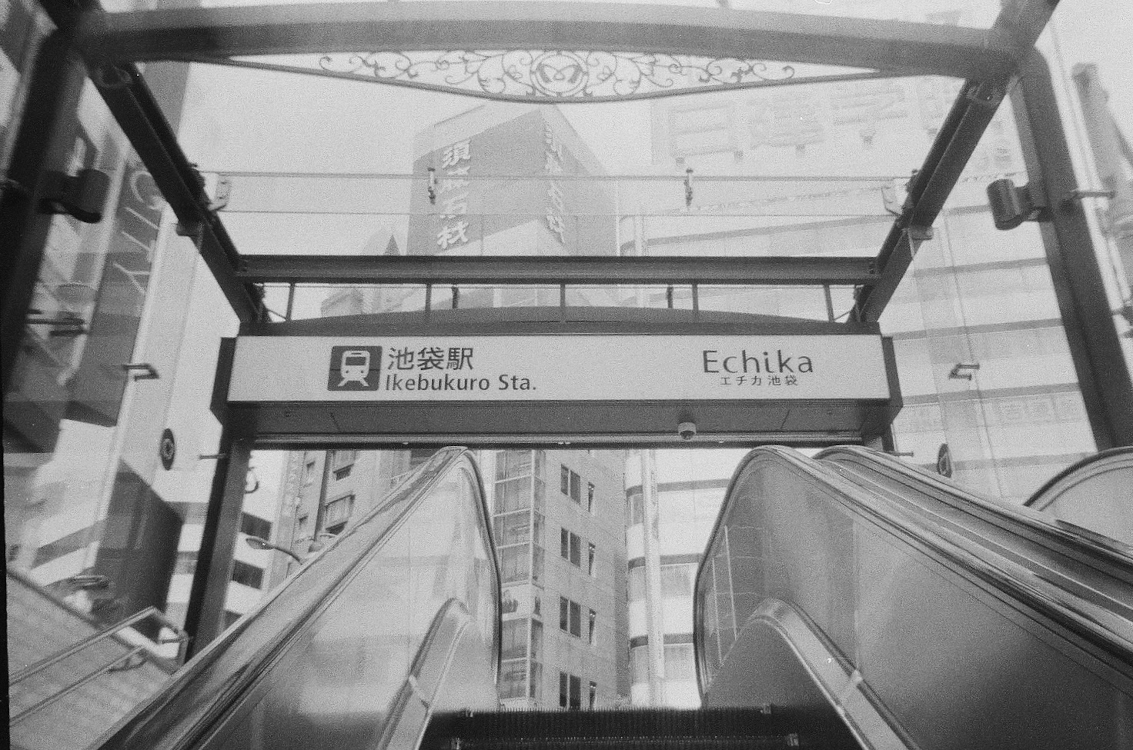 Urban scene with an escalator and station sign