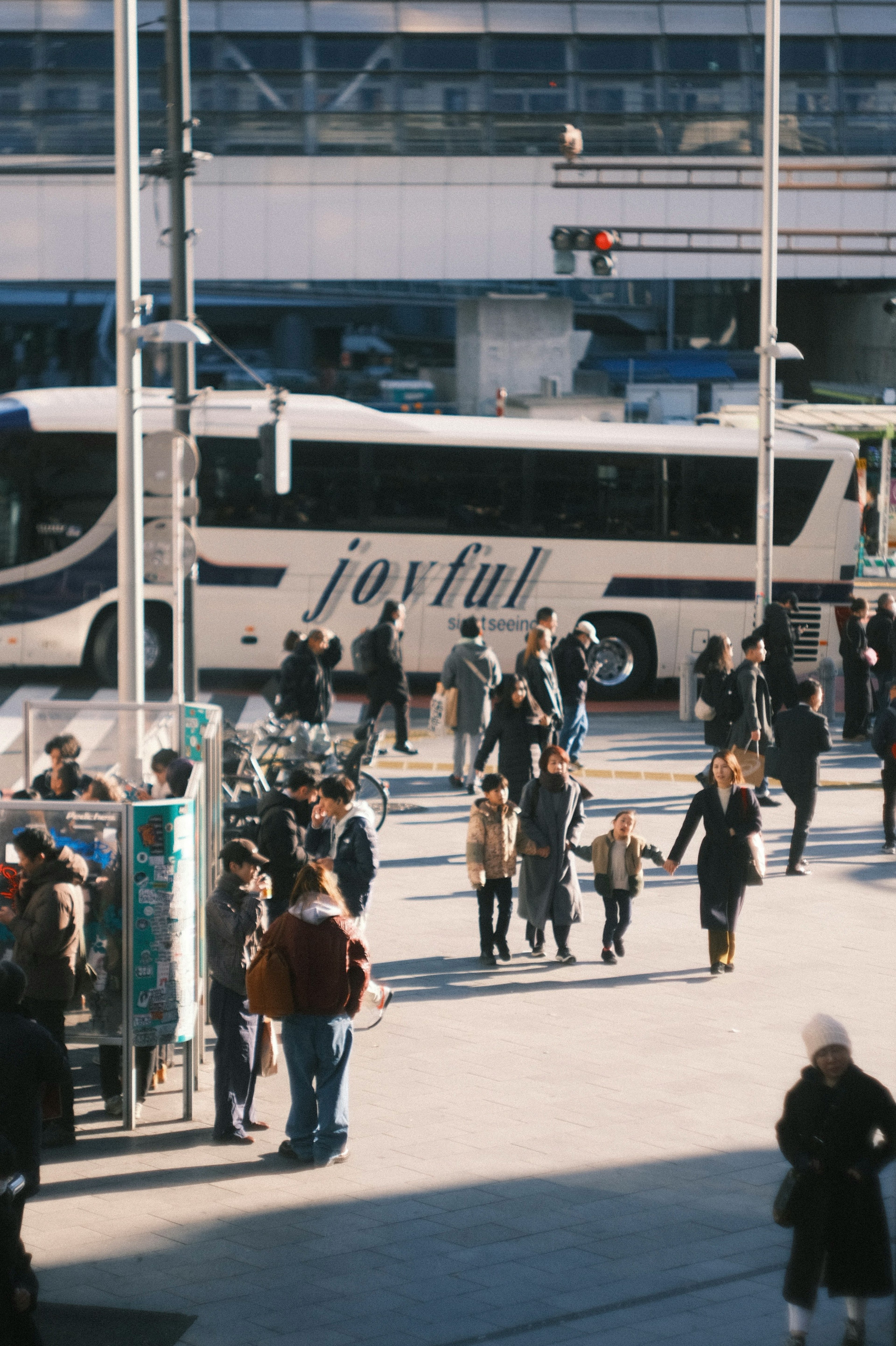 Busy city scene with people crossing near a bus stop