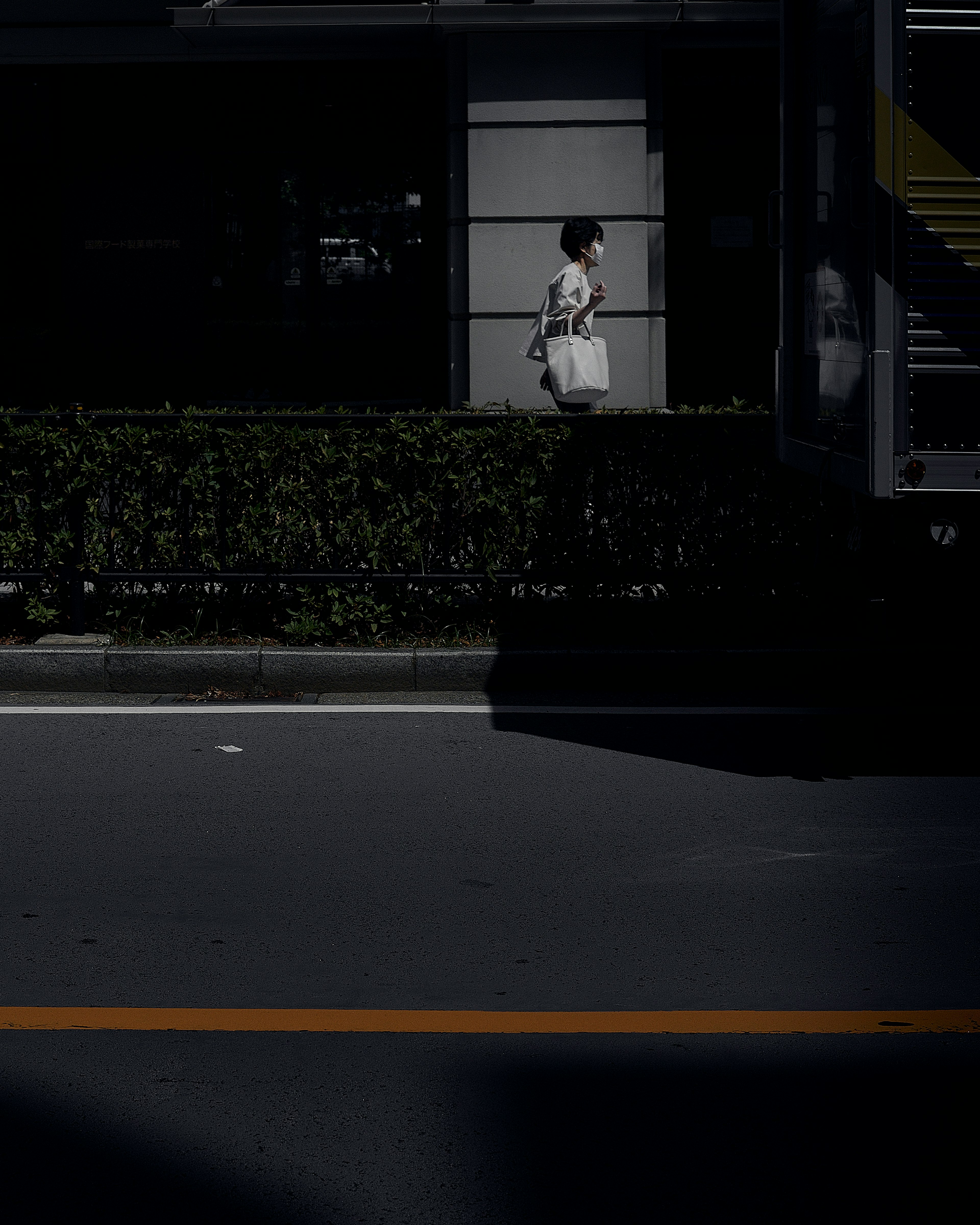 A woman standing against a dark background with urban scenery