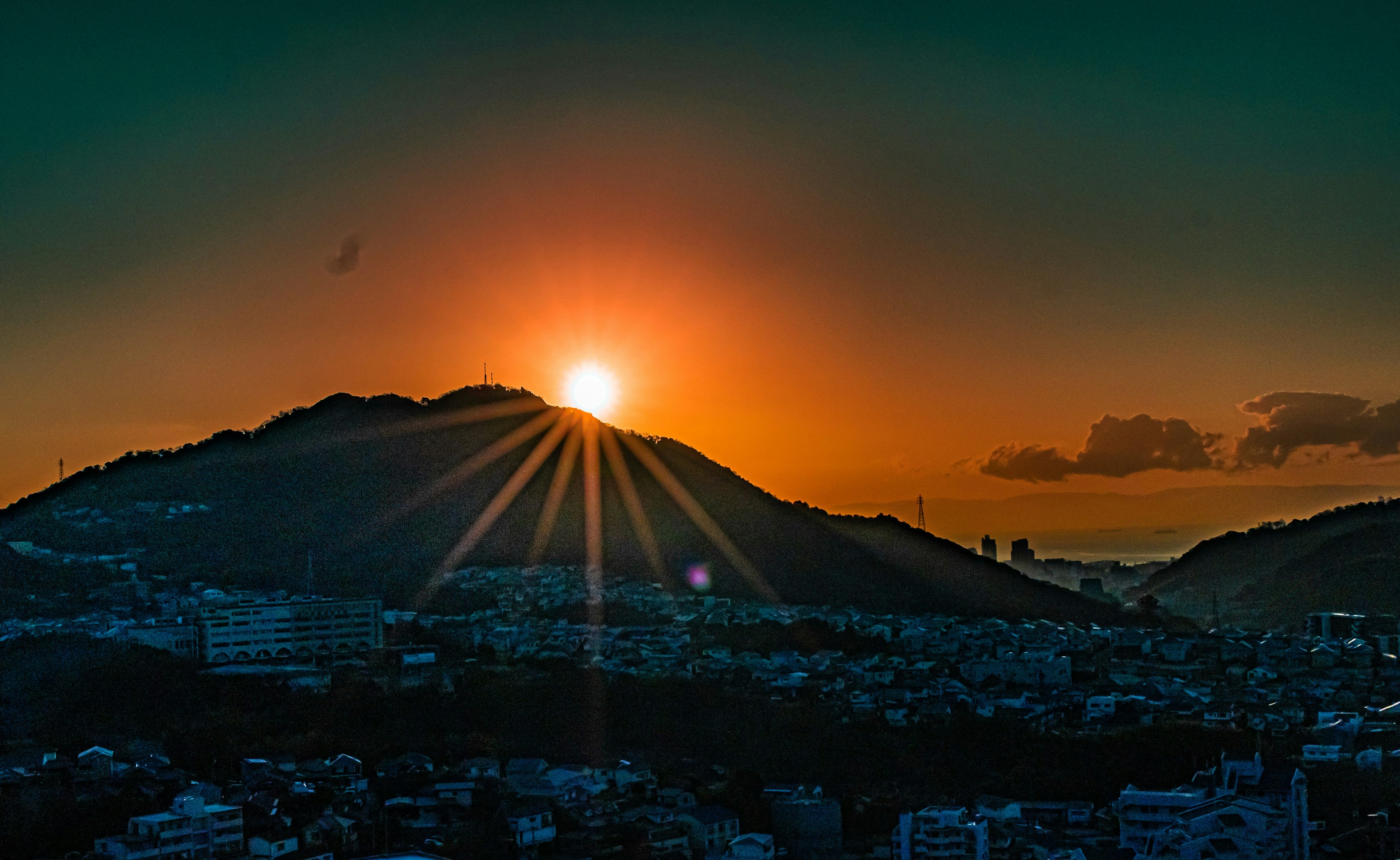 Sunrise over a mountain with radiant beams of light