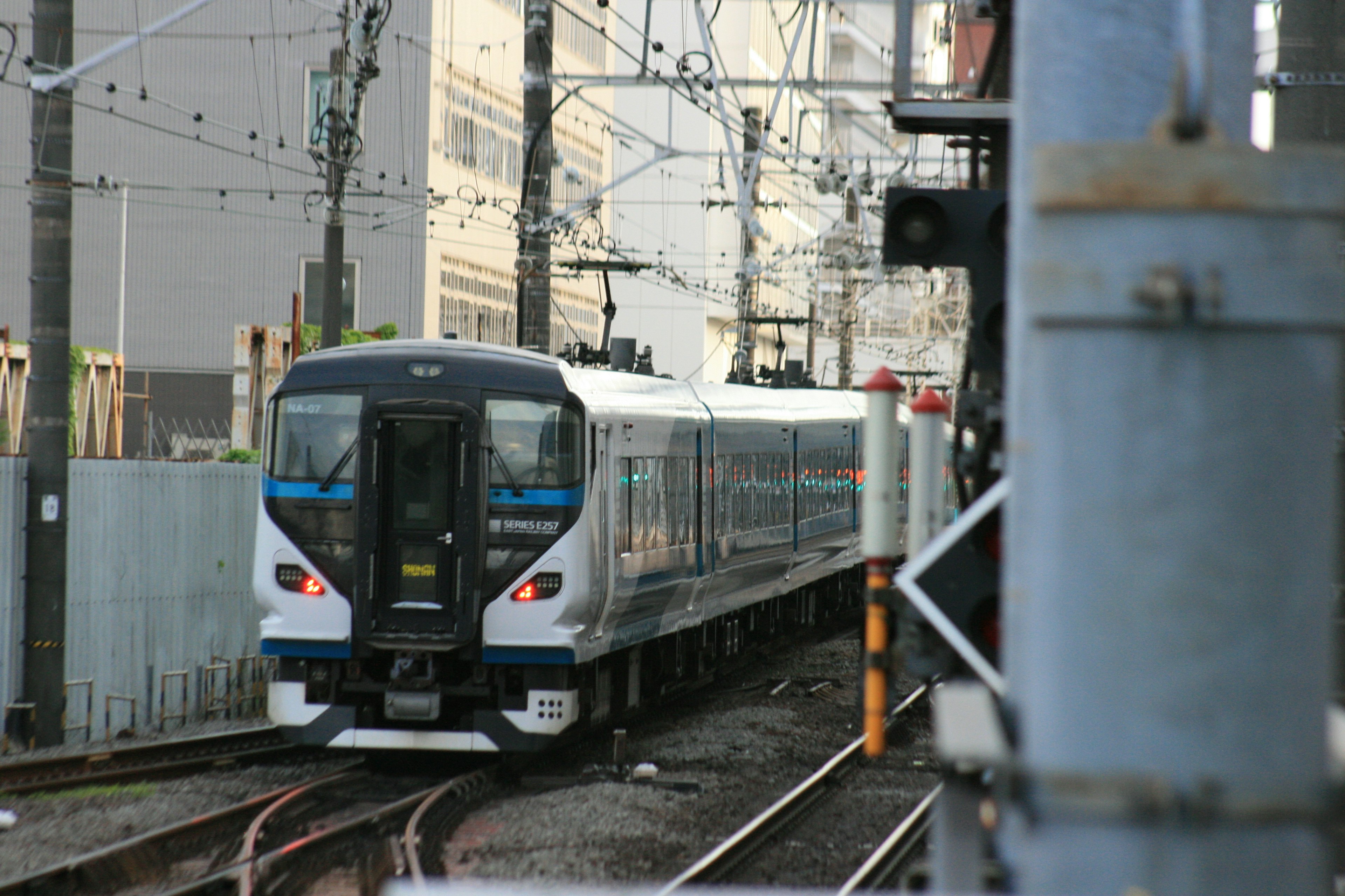 青い帯の電車が線路を走っている風景