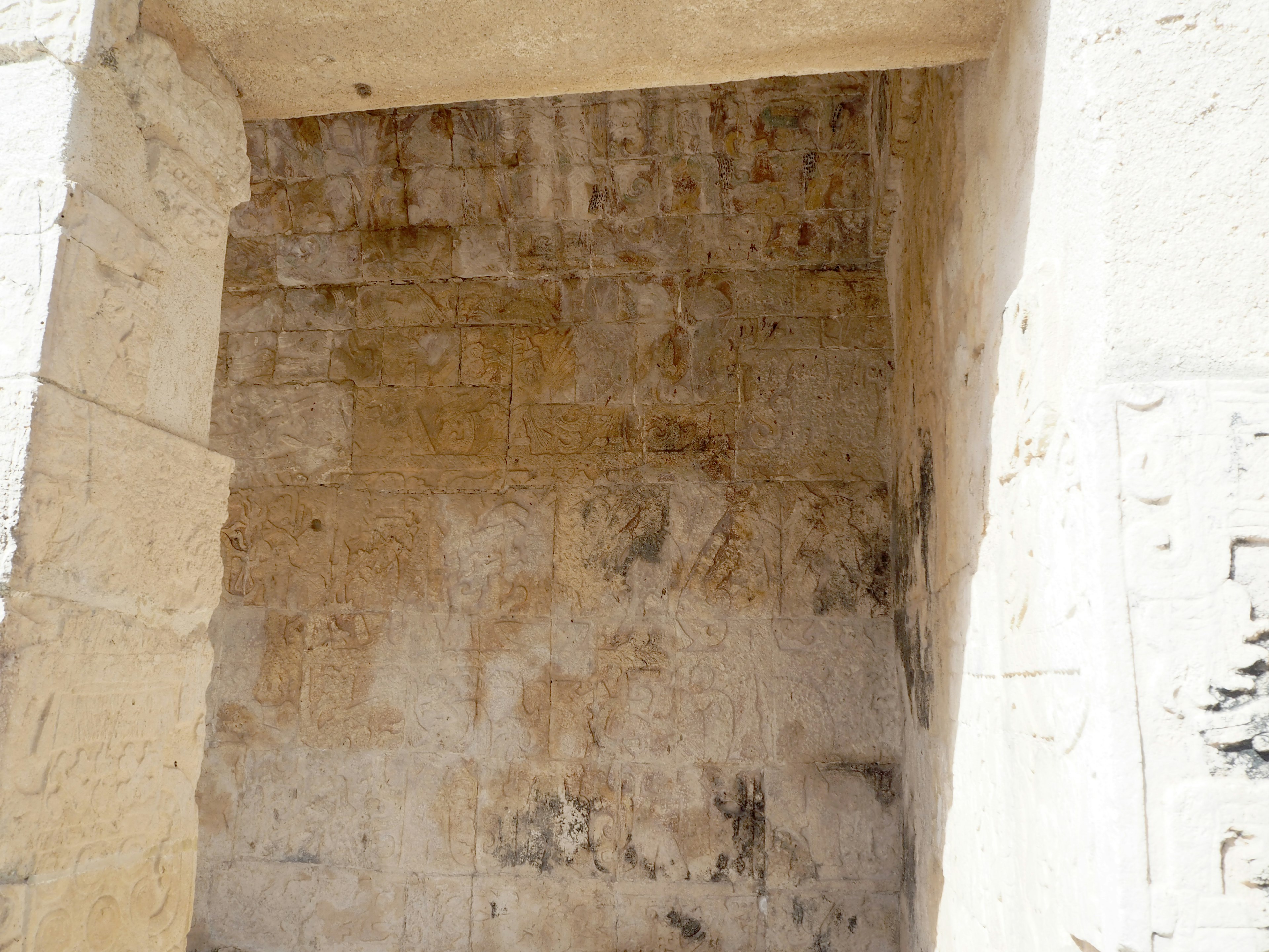 Vista interna di un antico muro di pietra con segni sbiaditi