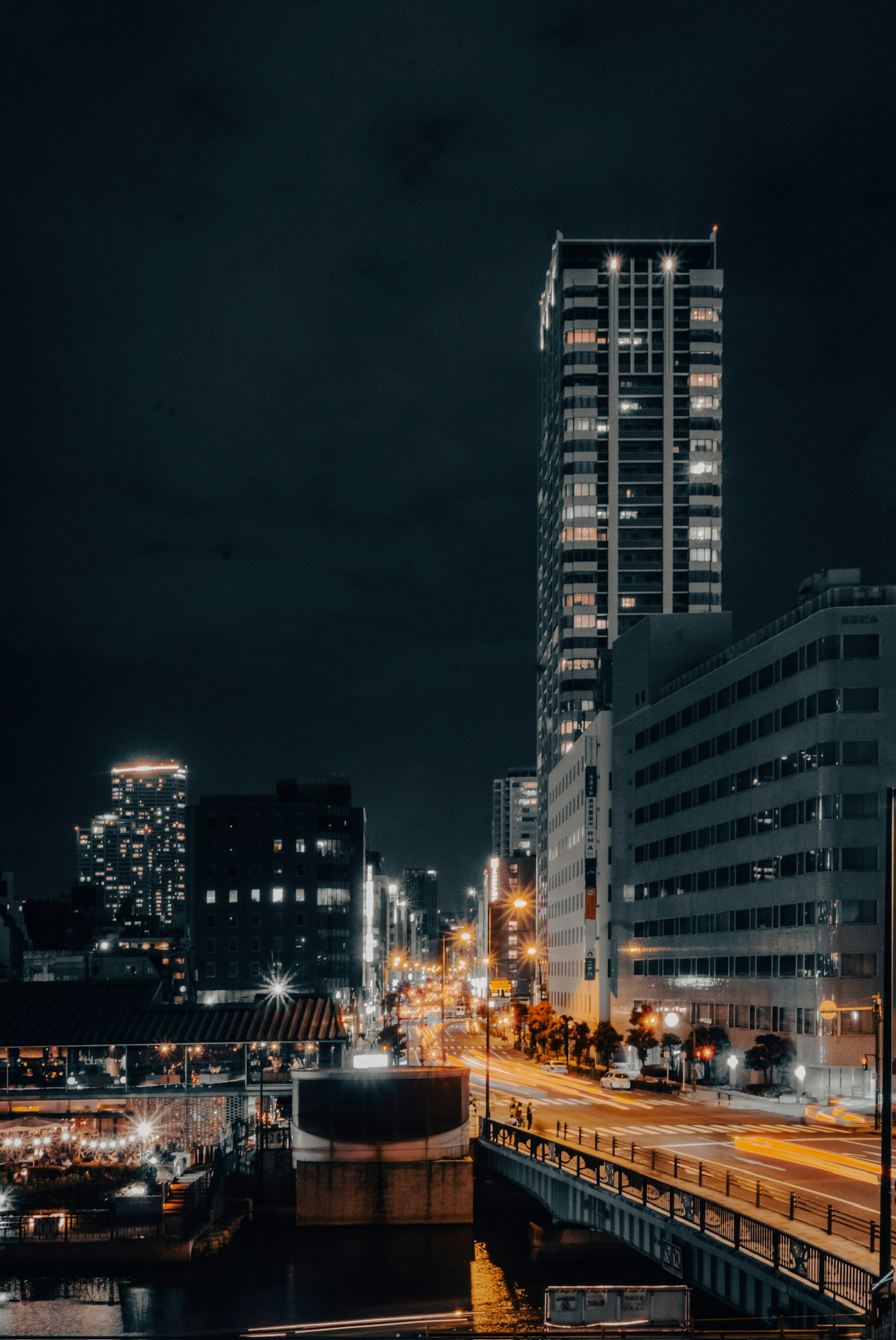 Paisaje urbano nocturno con edificios altos y calles iluminadas