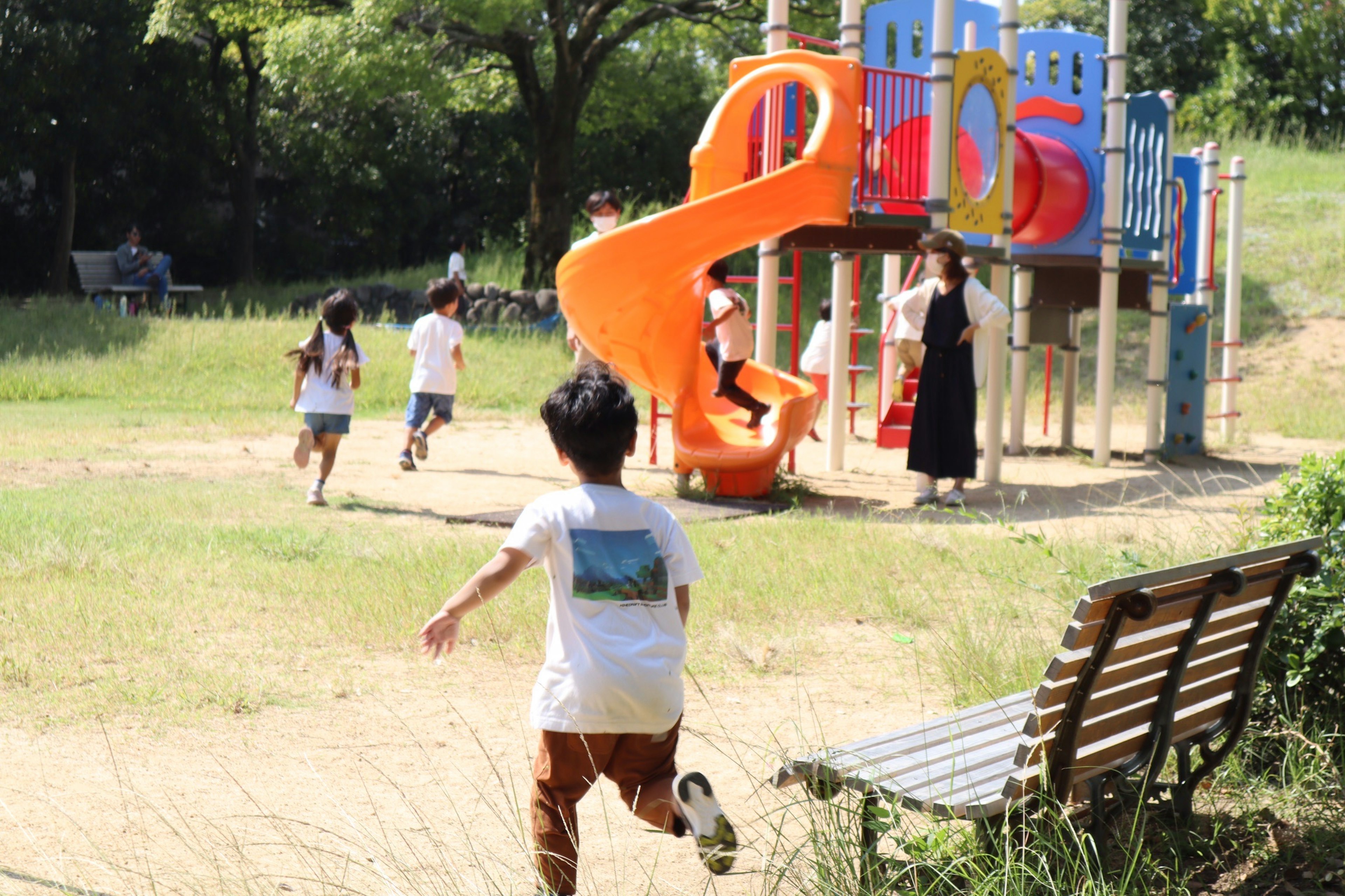 子供たちが遊んでいる公園の遊具とスライダー