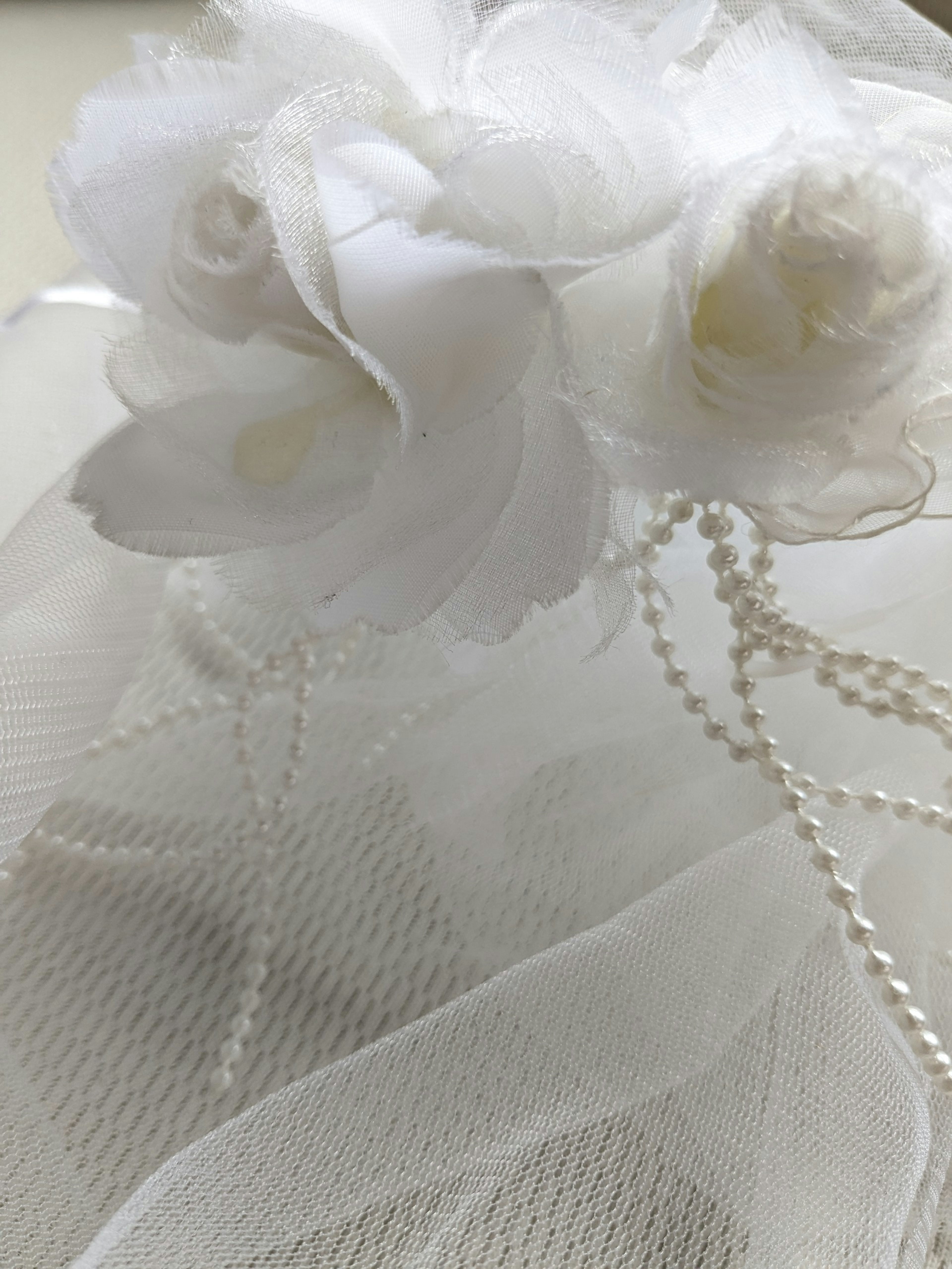 Soft decoration featuring white flowers and pearl beads