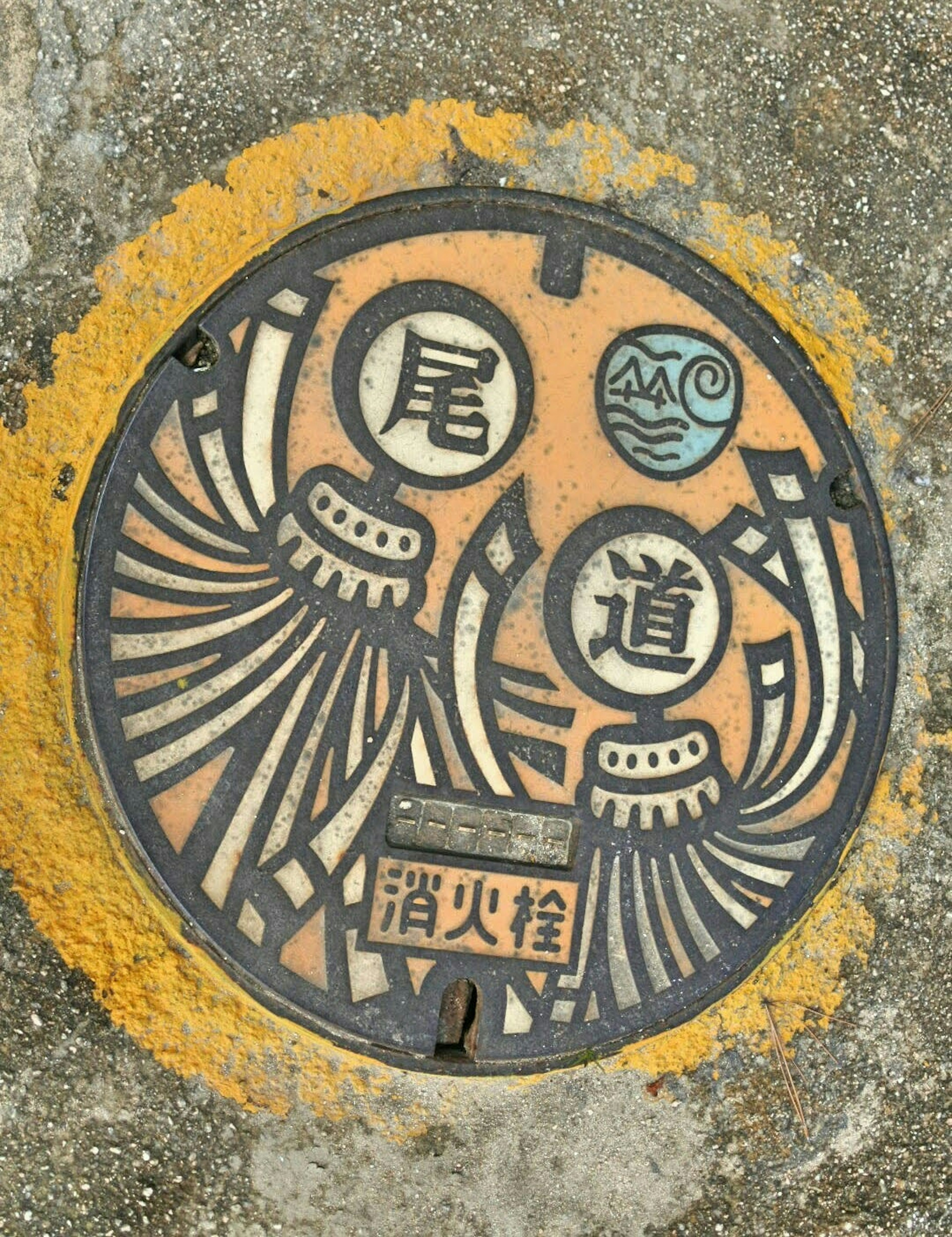 Round manhole cover featuring intricate design and text