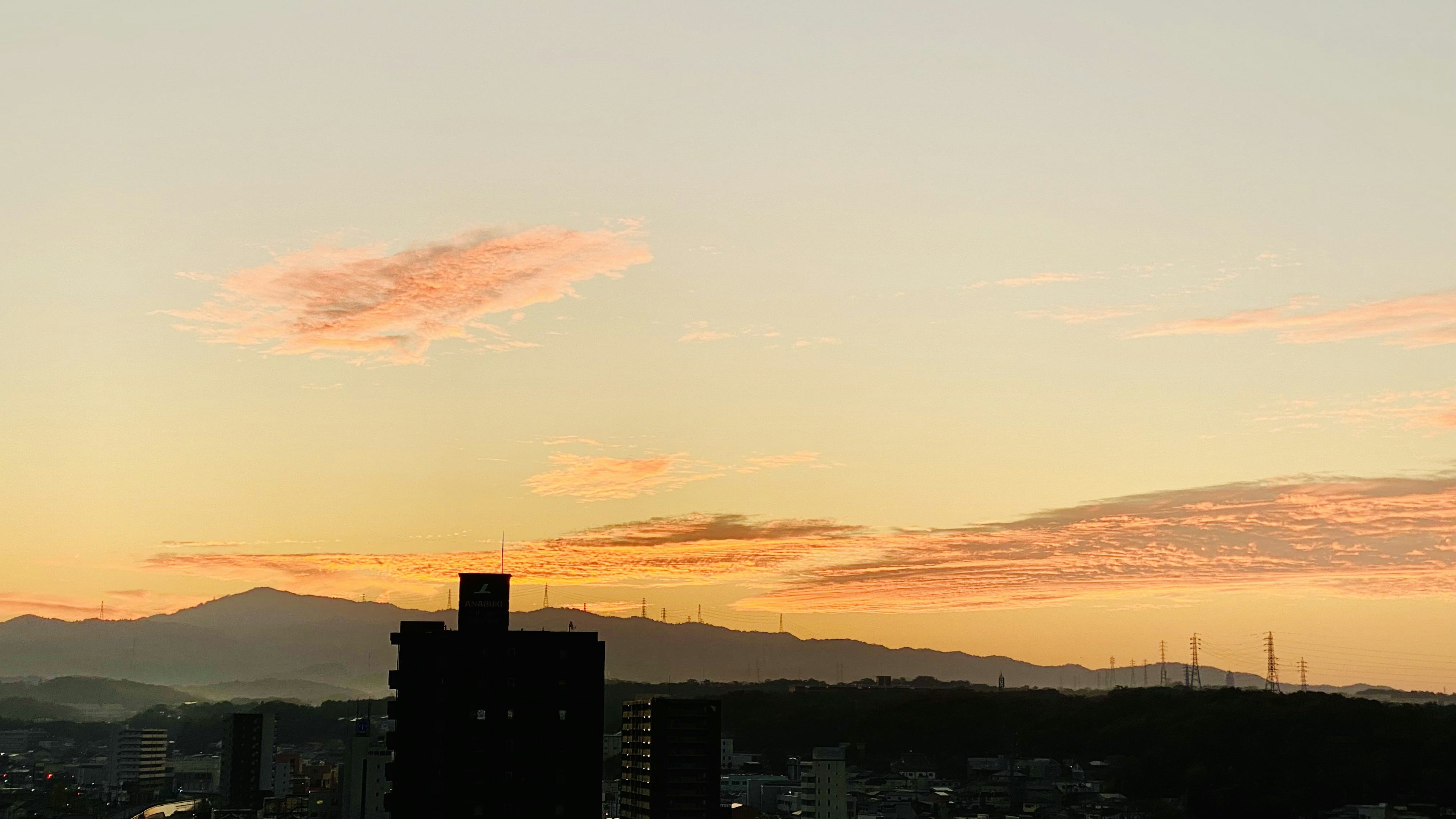 Sunset view with silhouettes of mountains and buildings