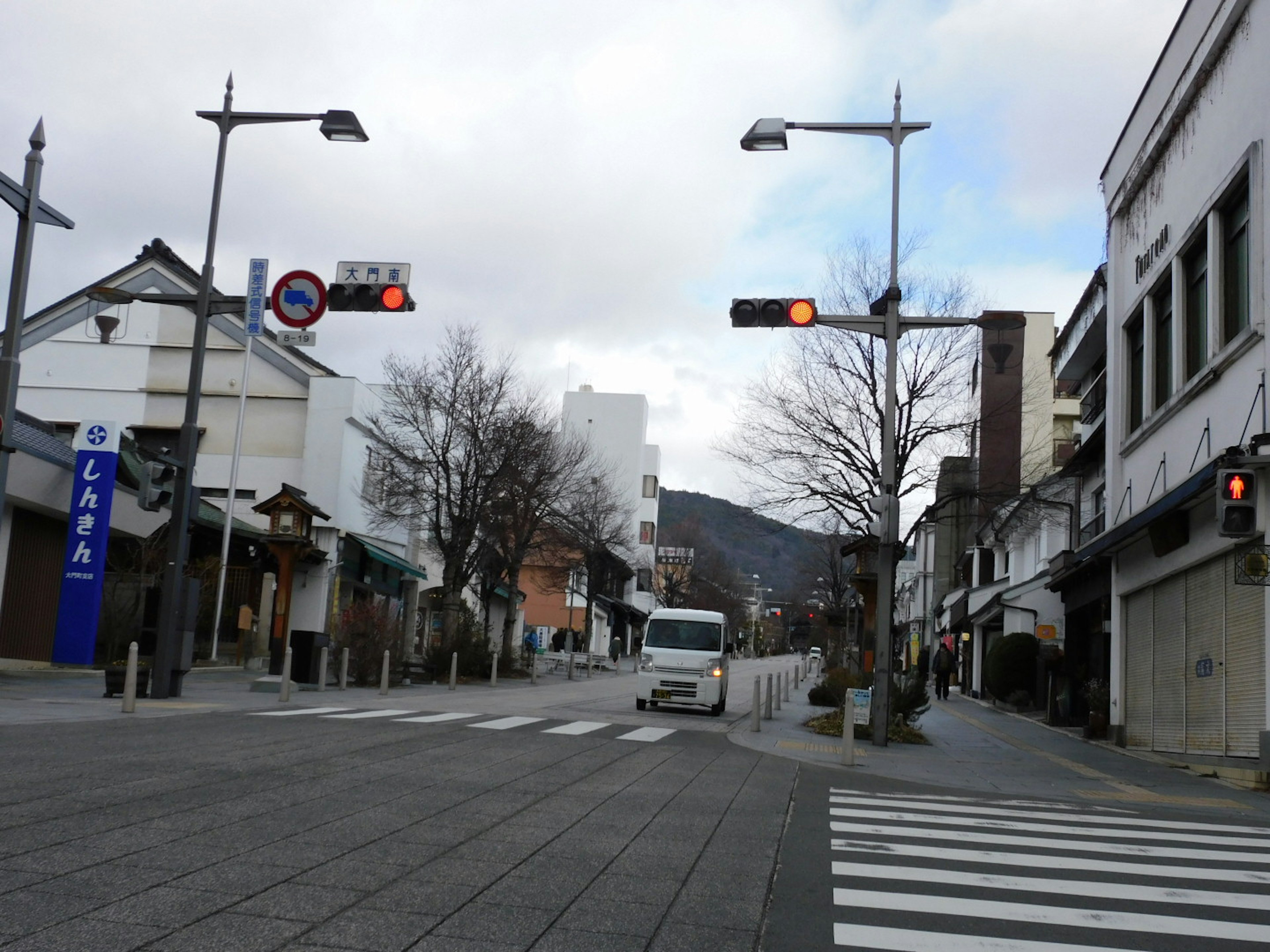 Quiet intersection featuring traffic signals and storefronts