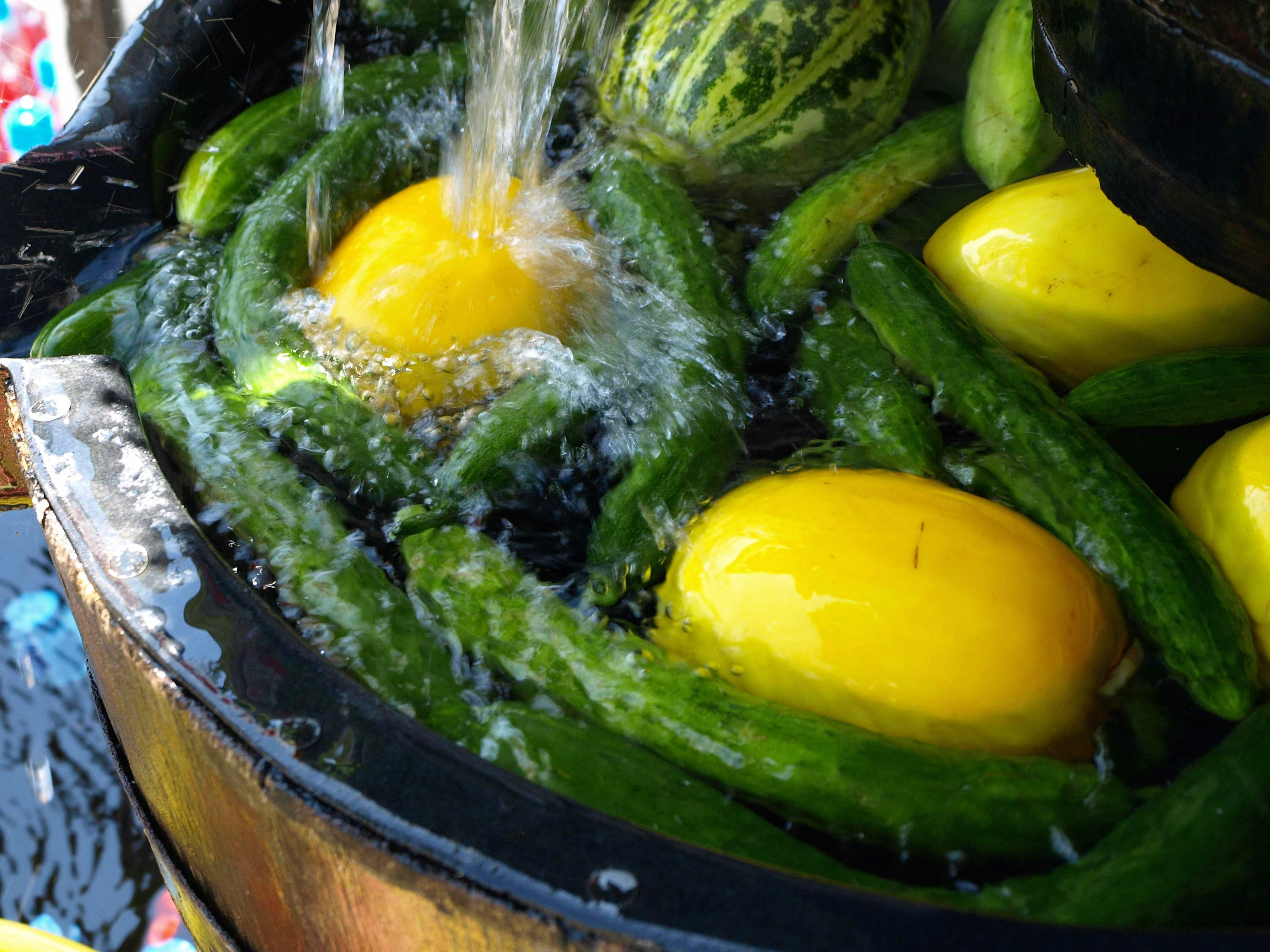 Cucumbers and yellow melons floating in water