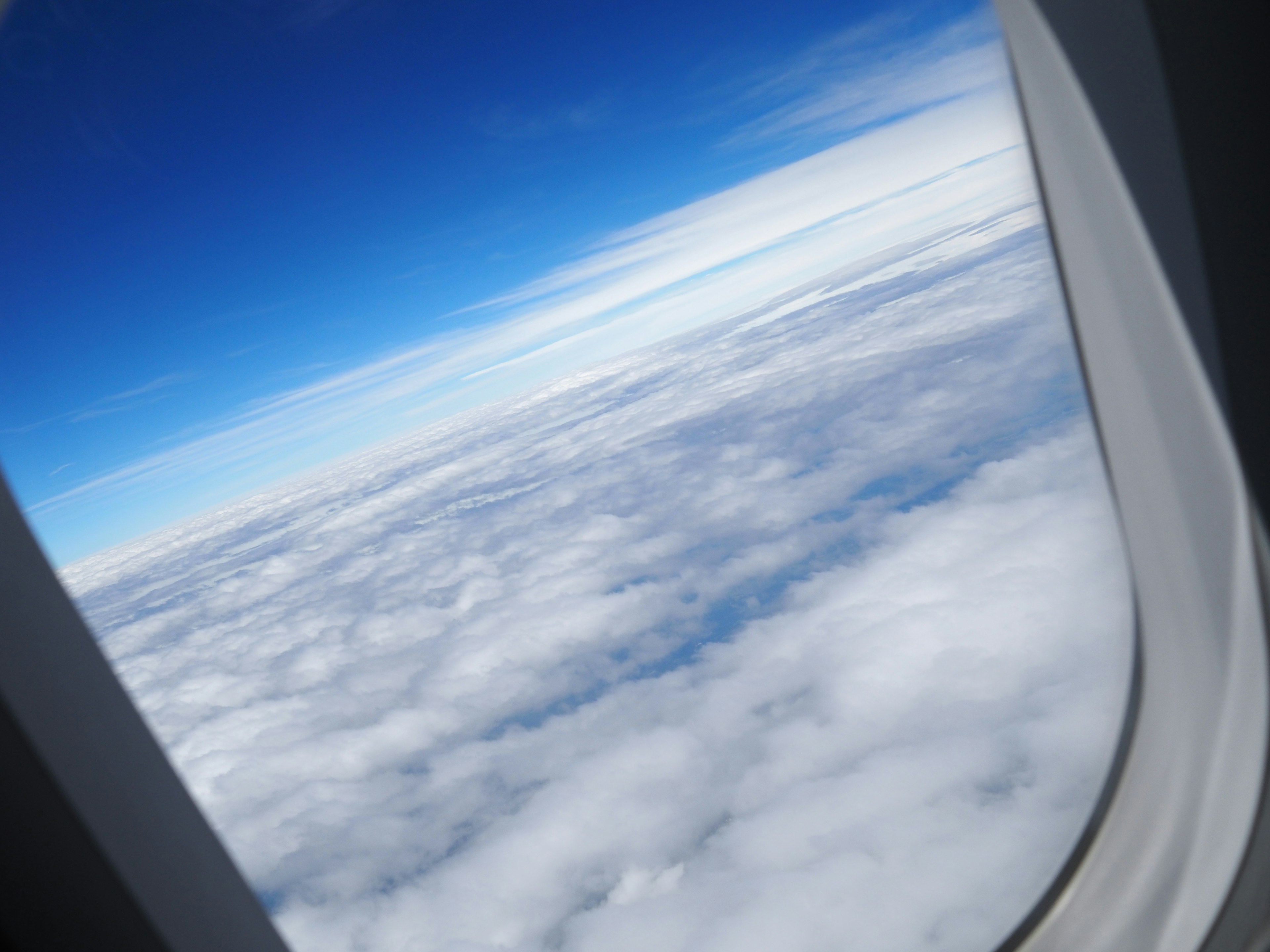 Aussicht auf Wolken und blauen Himmel aus einem Flugzeugfenster