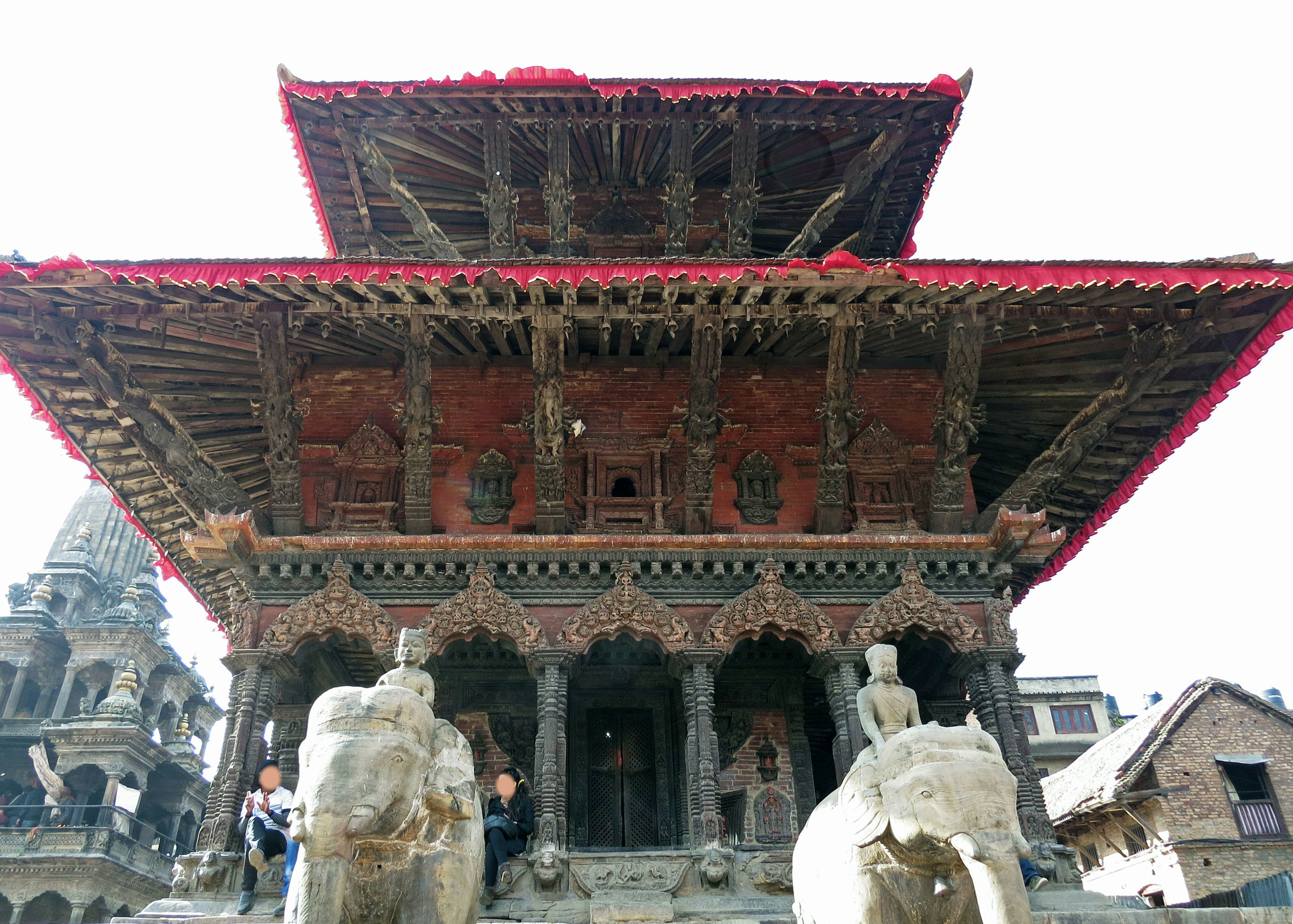 Vista frontale di un tempio nepalese tradizionale con grandi statue di elefanti scolpite