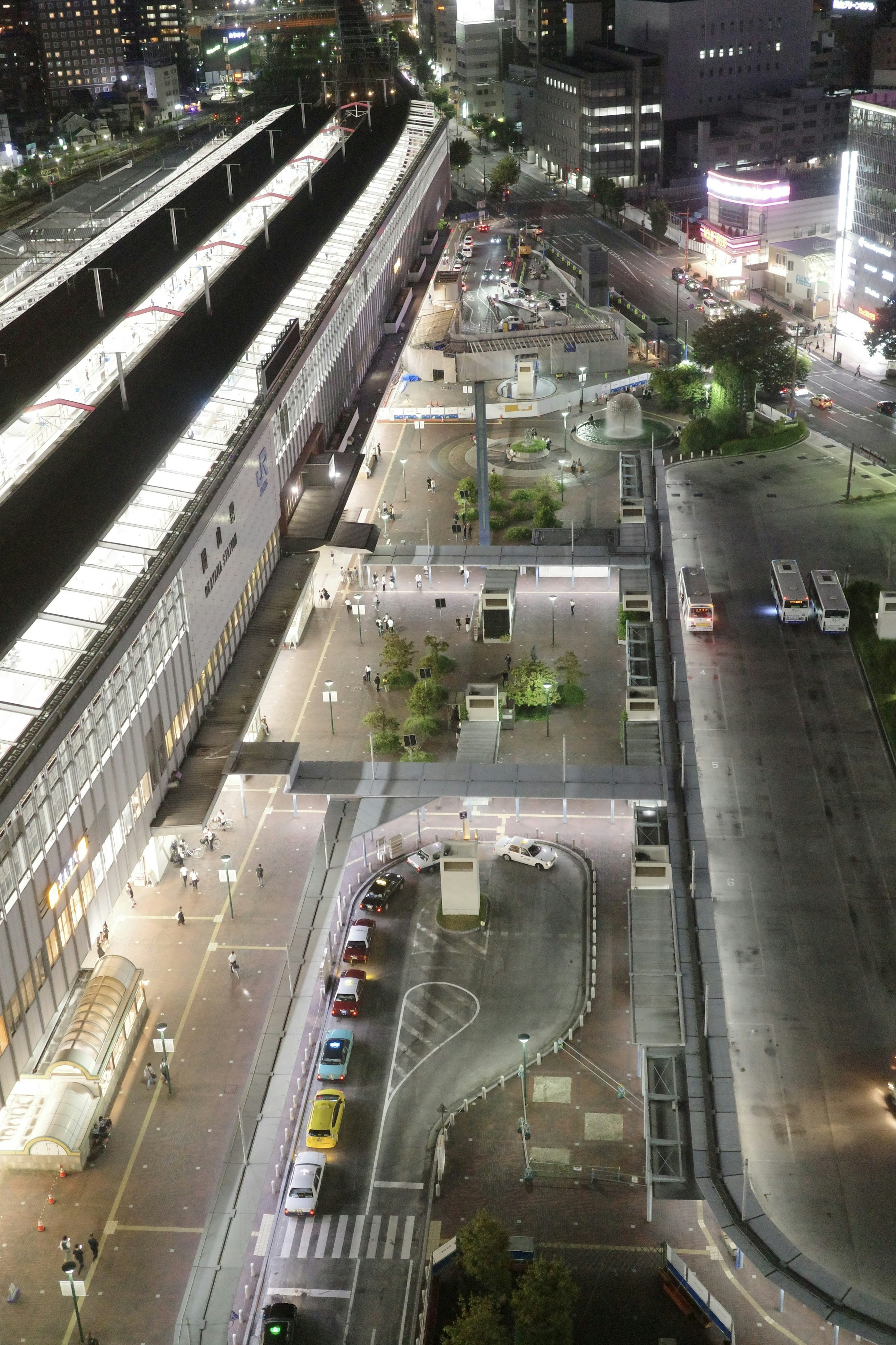 Paisaje urbano nocturno con área de estación iluminada y diseño de carreteras