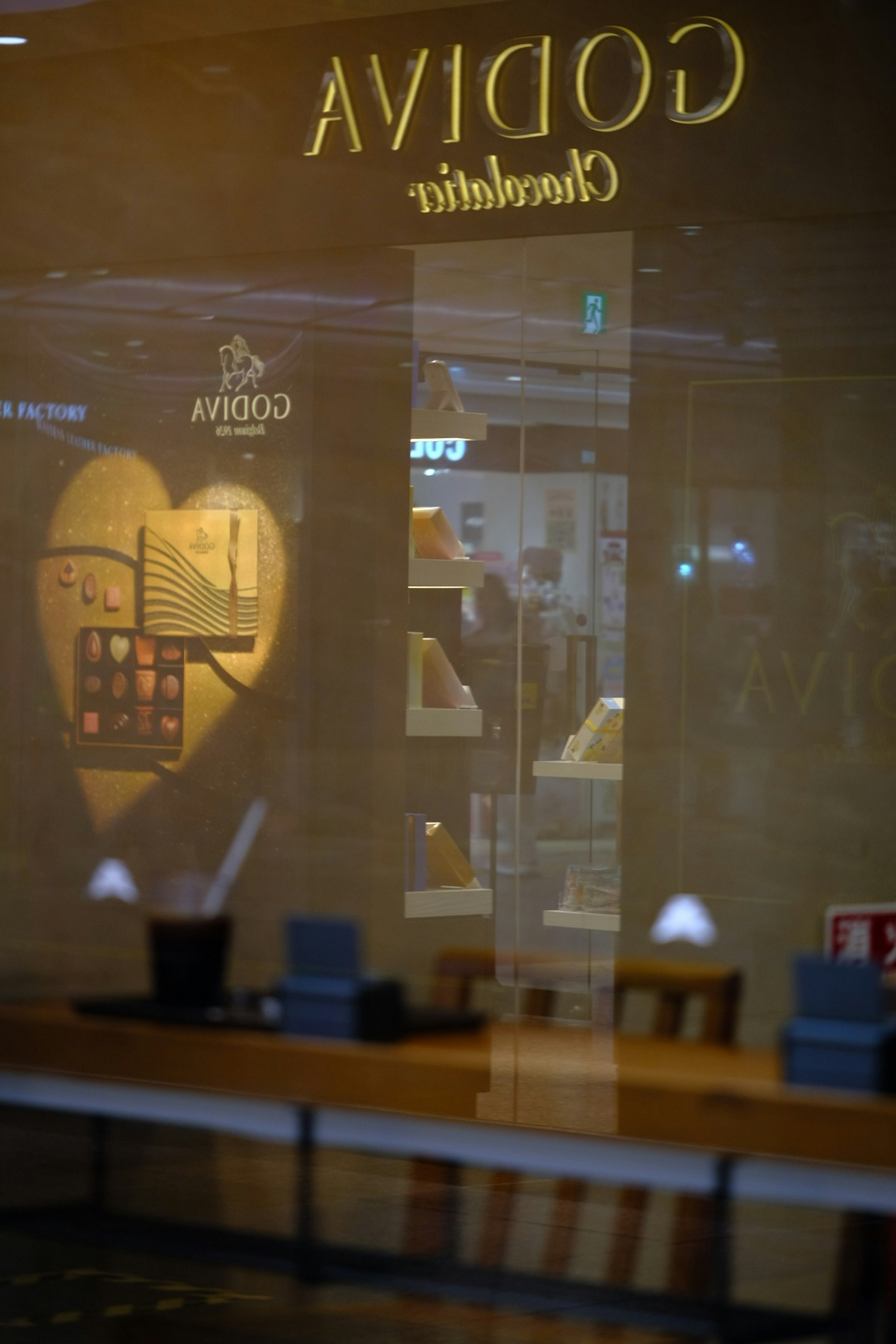 Reflejo del interior de la tienda Godiva en la ventana