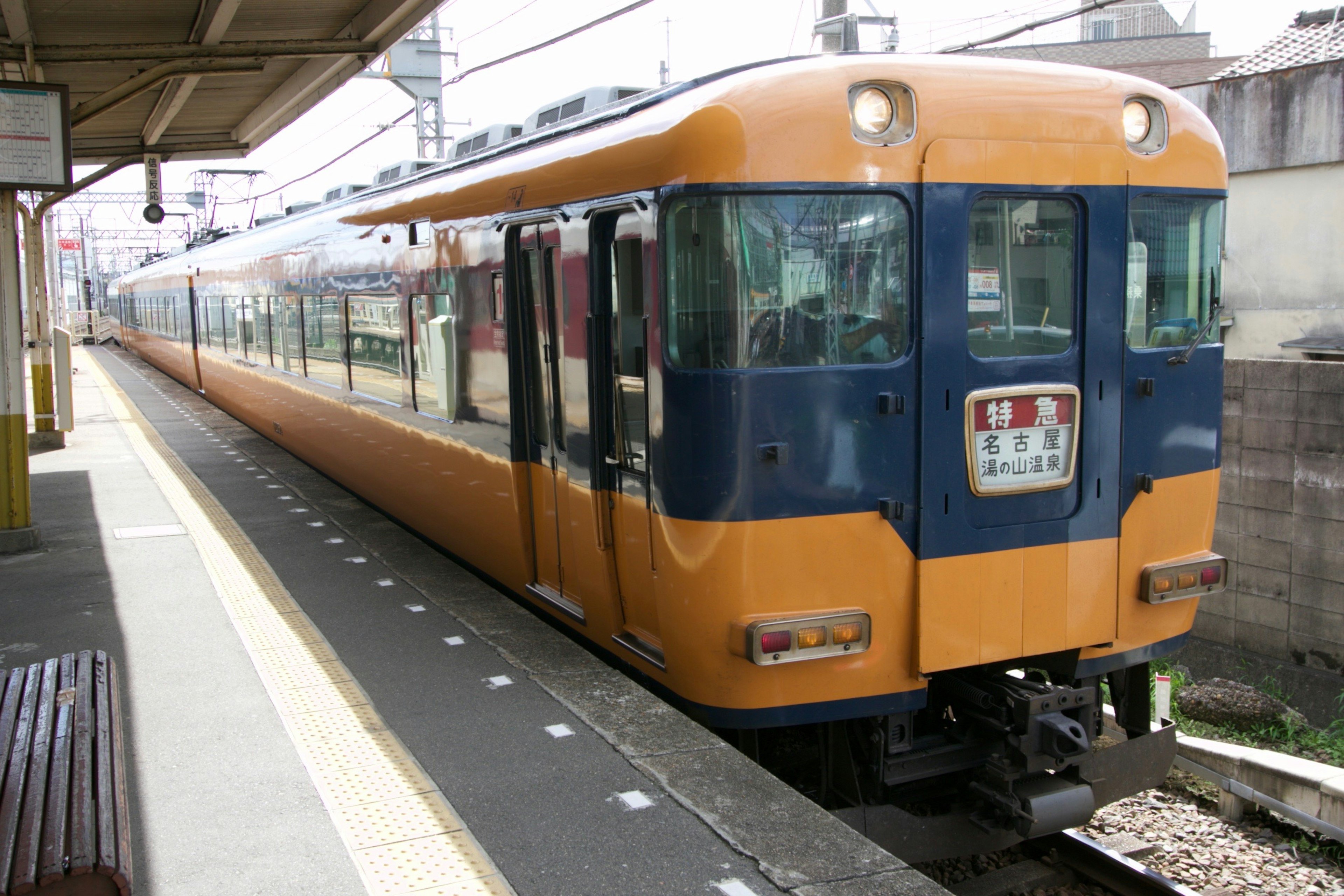 Un treno arancione e blu è fermo in una stazione