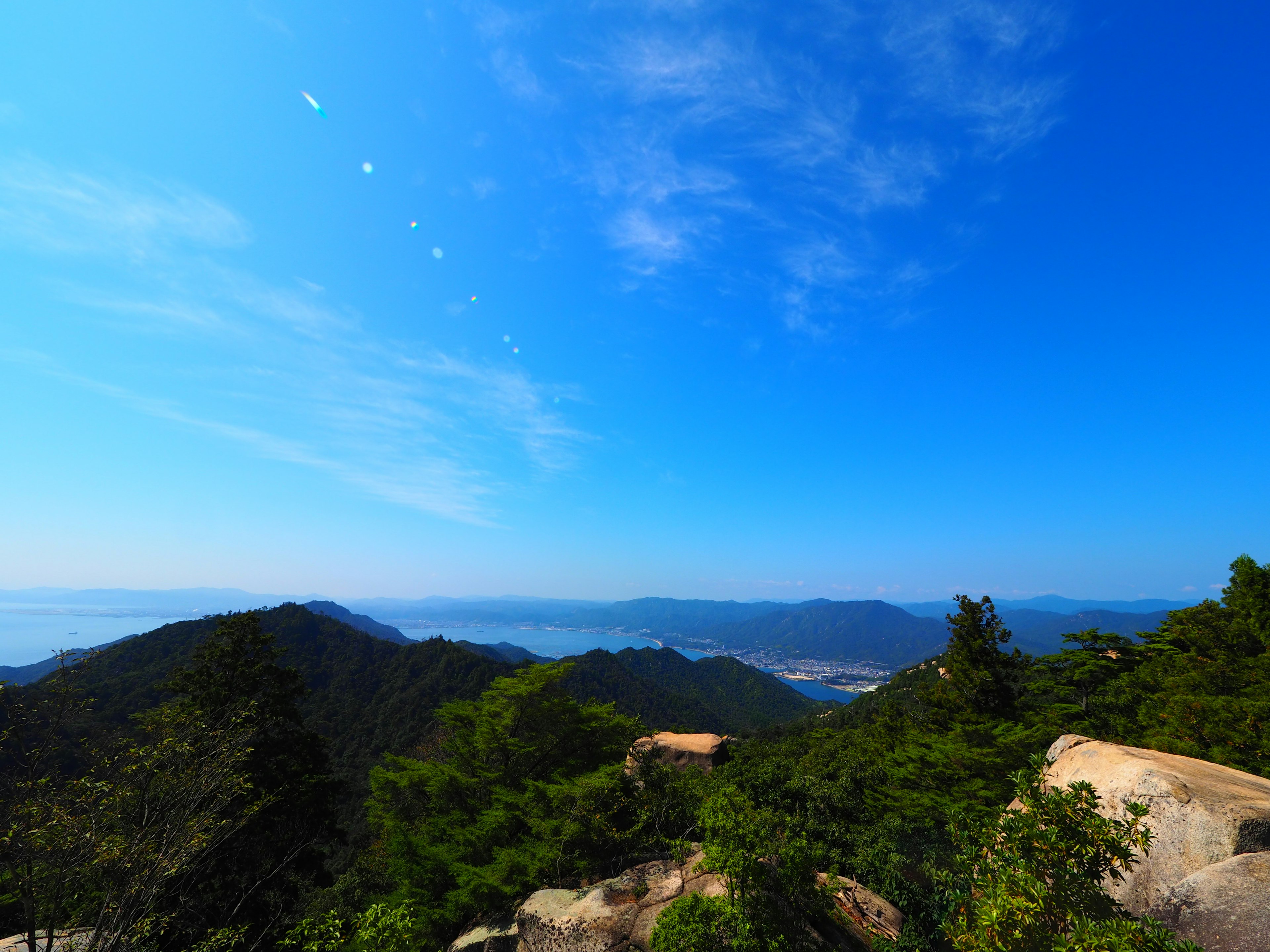 青空と山々の美しい風景 緑の木々と岩が特徴的