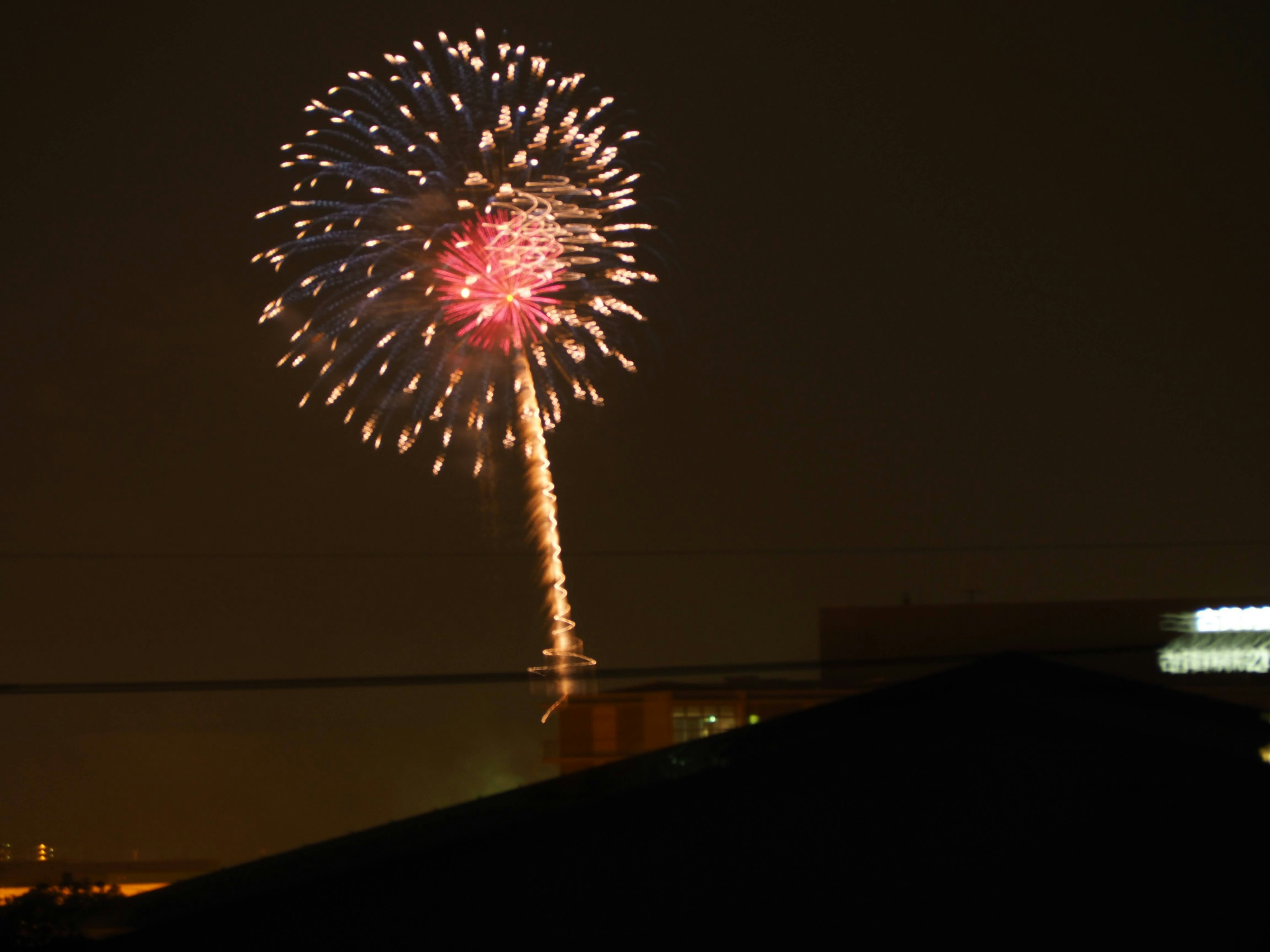 夜空に咲く花火の美しい光景赤い中心と周囲の光の輪が印象的