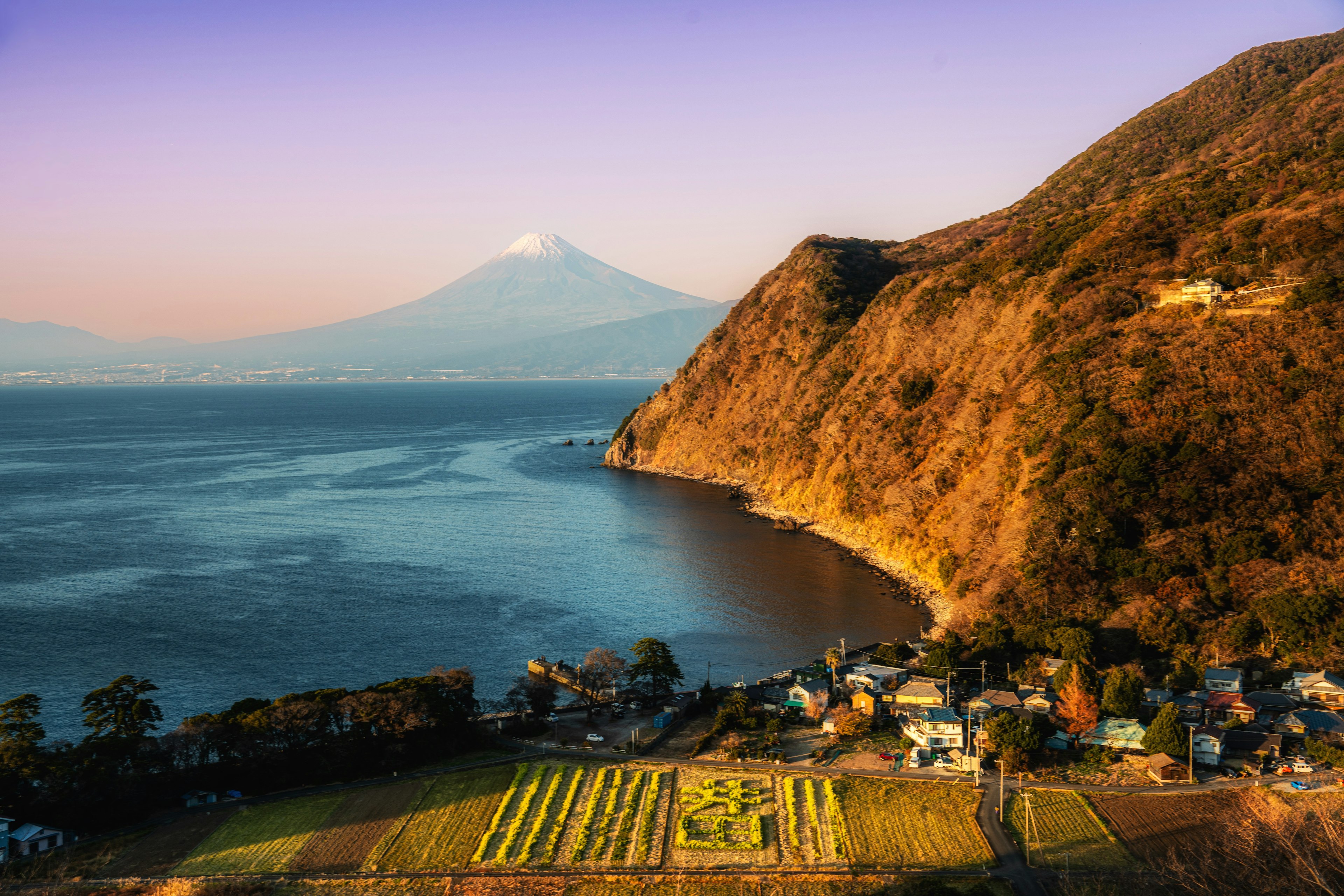 富士山背景下的湖泊和山丘風景 日落時柔和的光線映射在景觀上