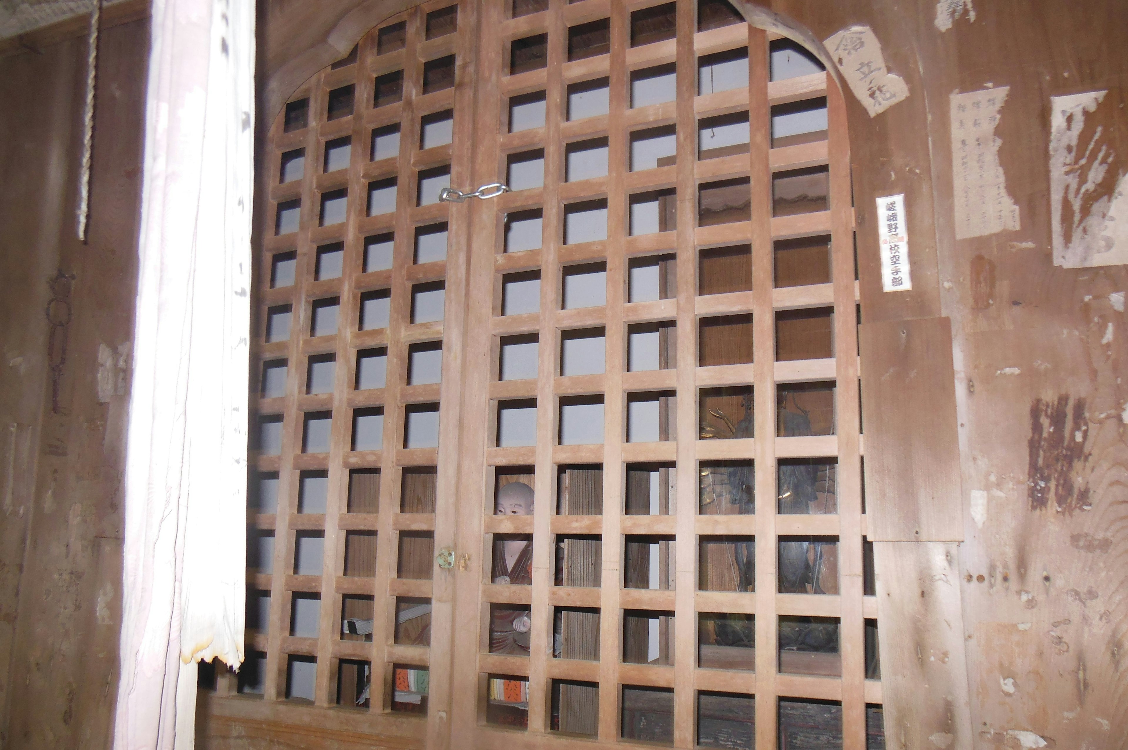 A section of a wall featuring an old wooden lattice door