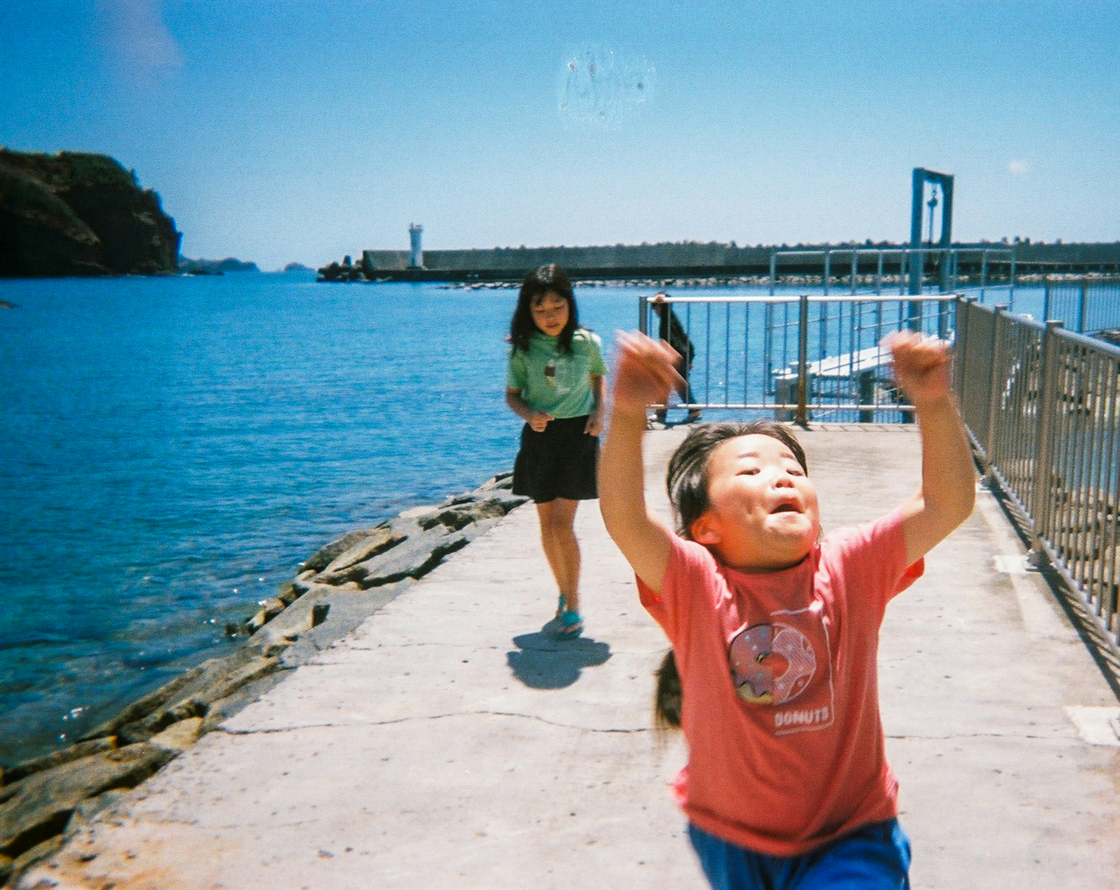 A child joyfully running along a coastal path