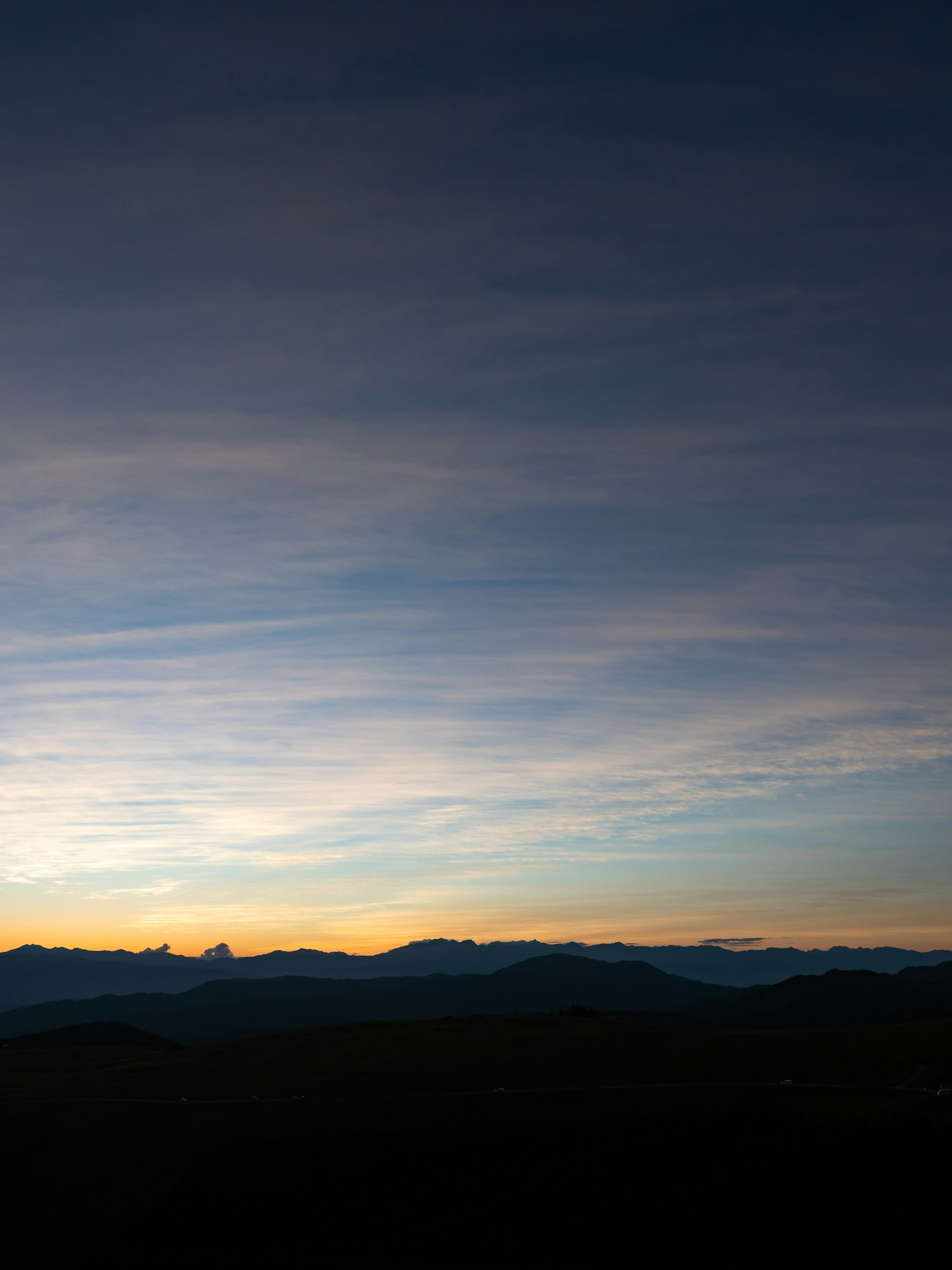 Ciel en dégradé avec des teintes bleues et orange et montagnes en silhouette