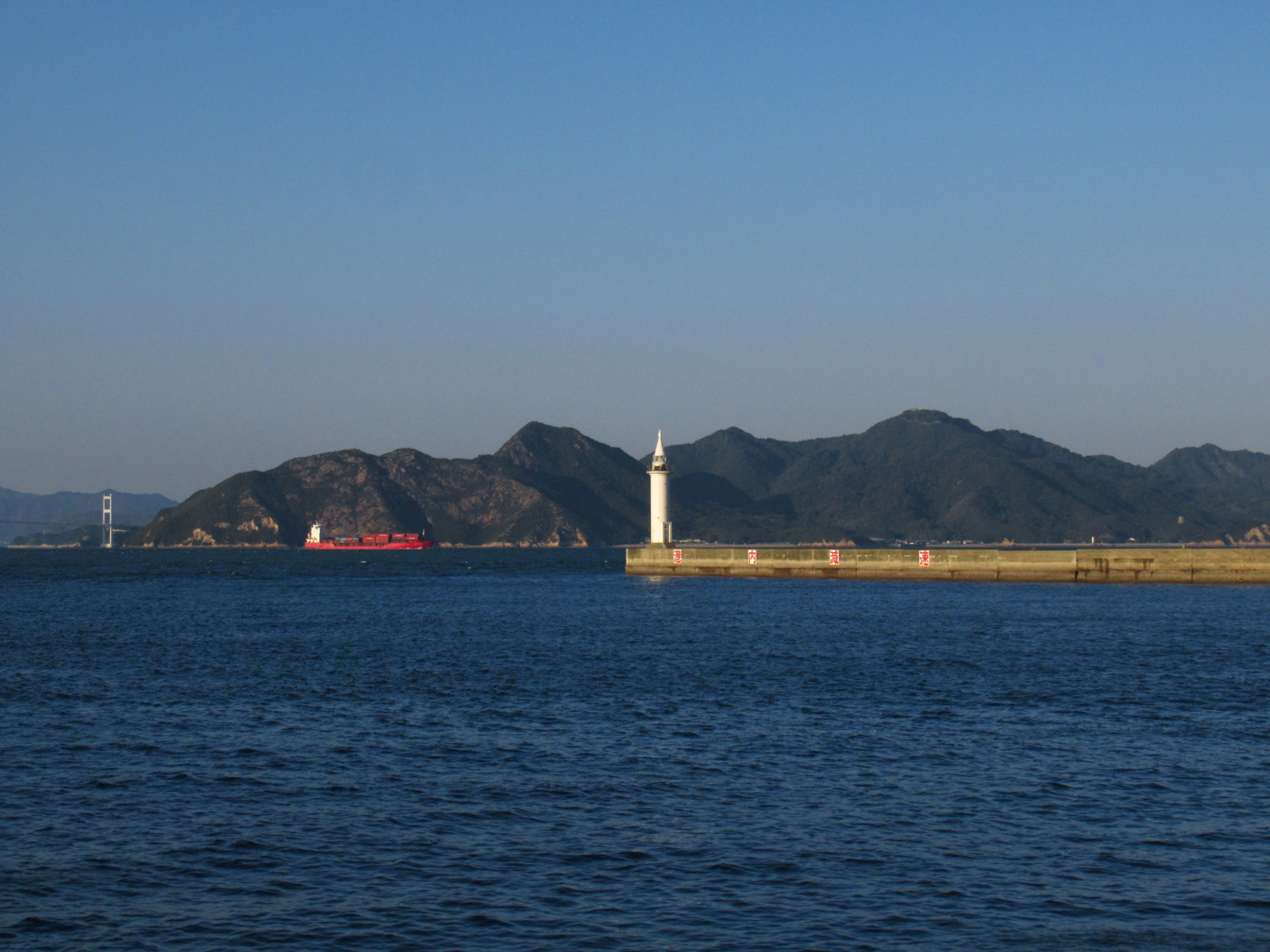 海と灯台の風景 船が近くを通過している