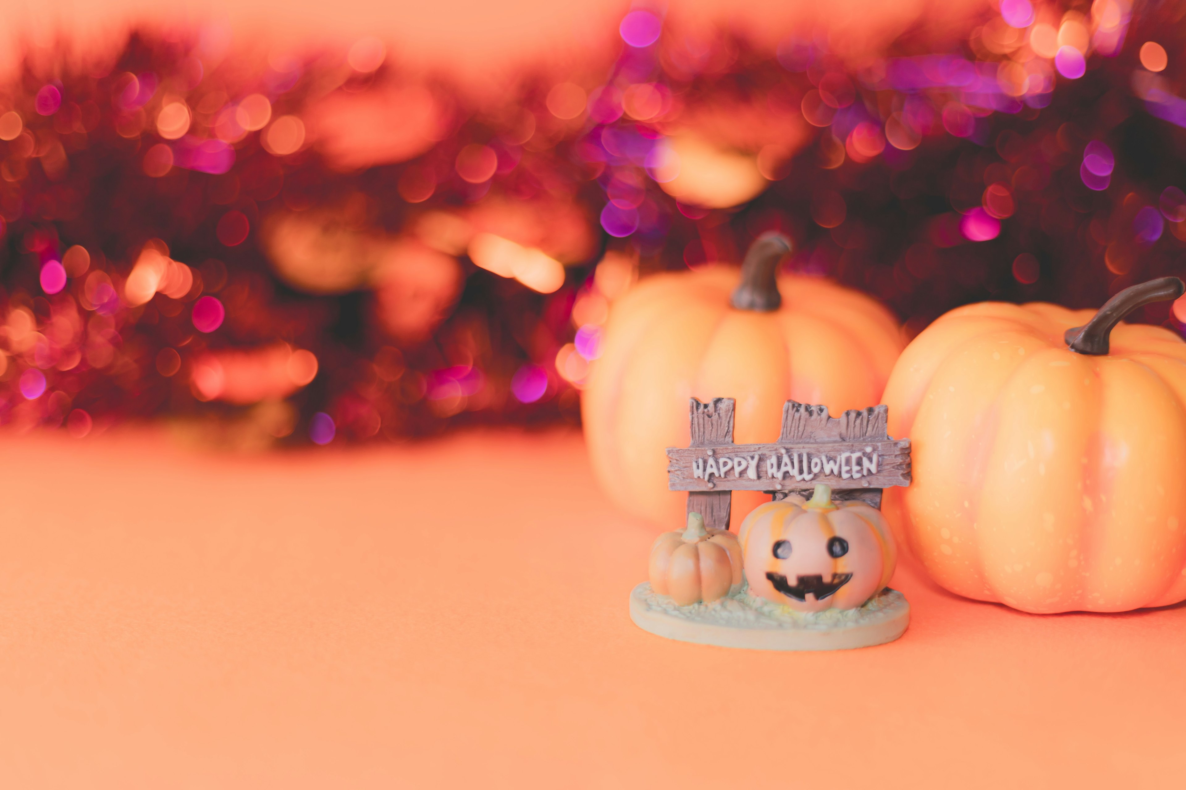 A decorative Halloween scene featuring small pumpkins and a cute faced ornament