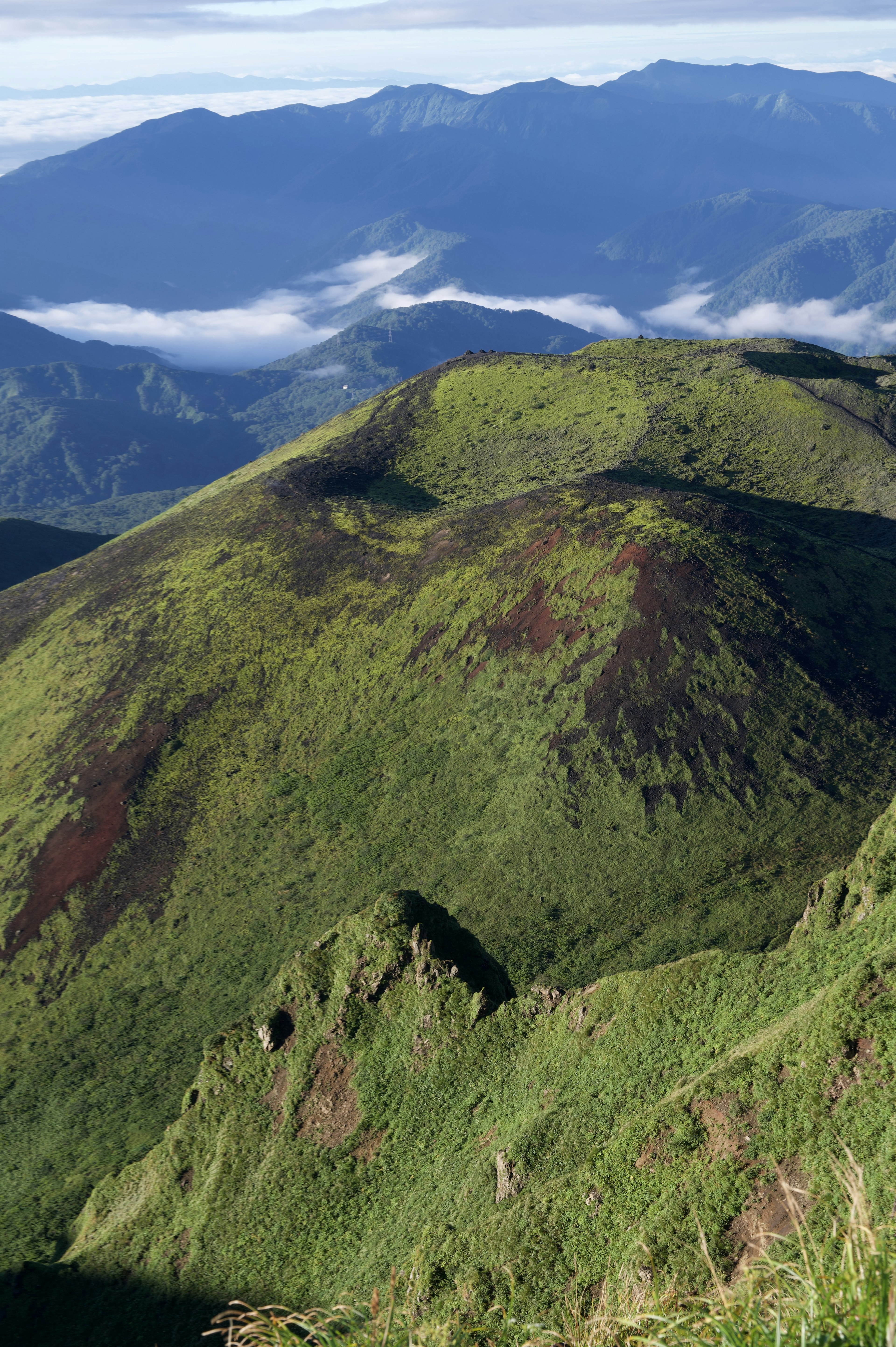 Paysage montagneux verdoyant avec des sommets lointains