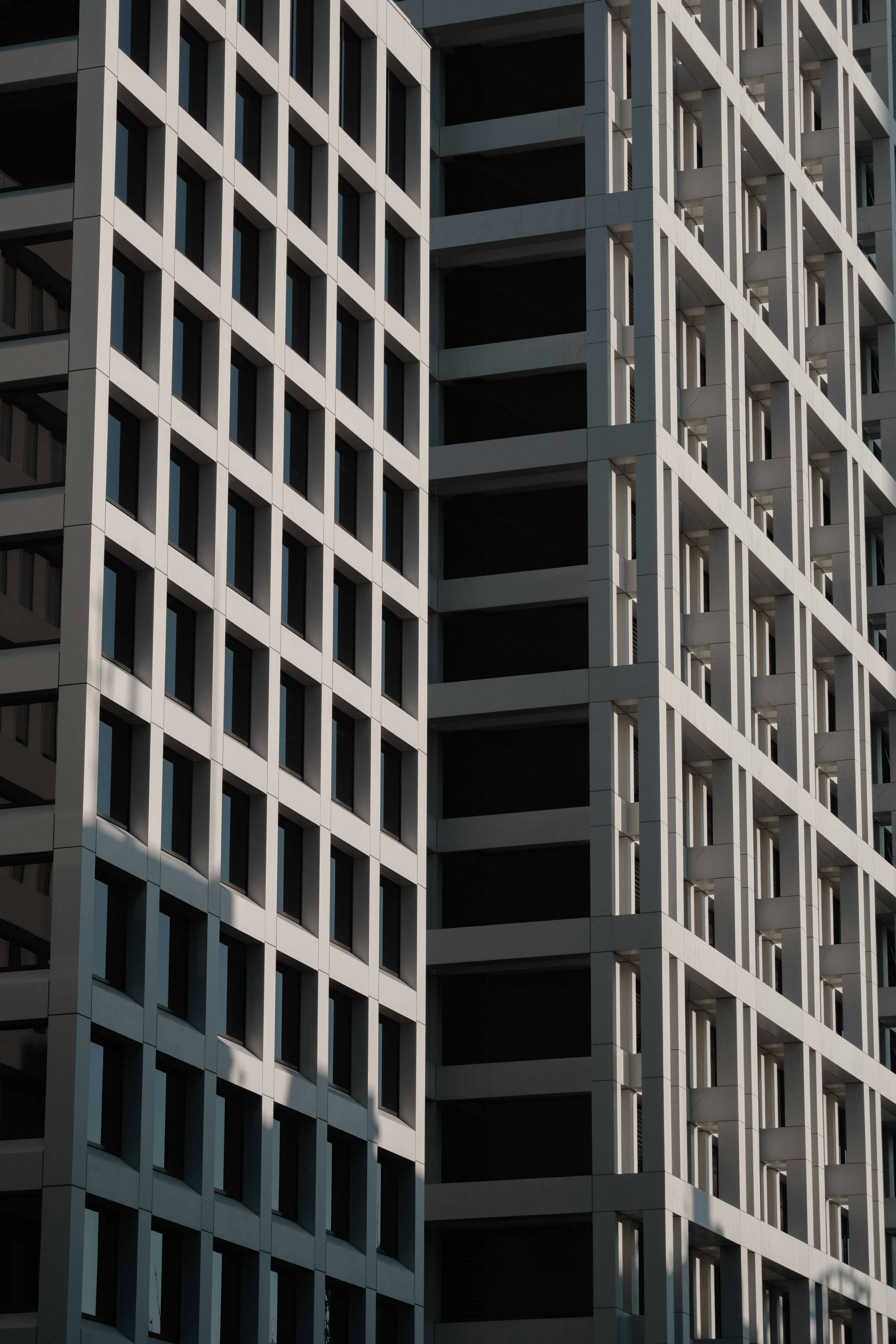 Imagen de la fachada de un edificio moderno con ventanas verticales y sombras distintivas