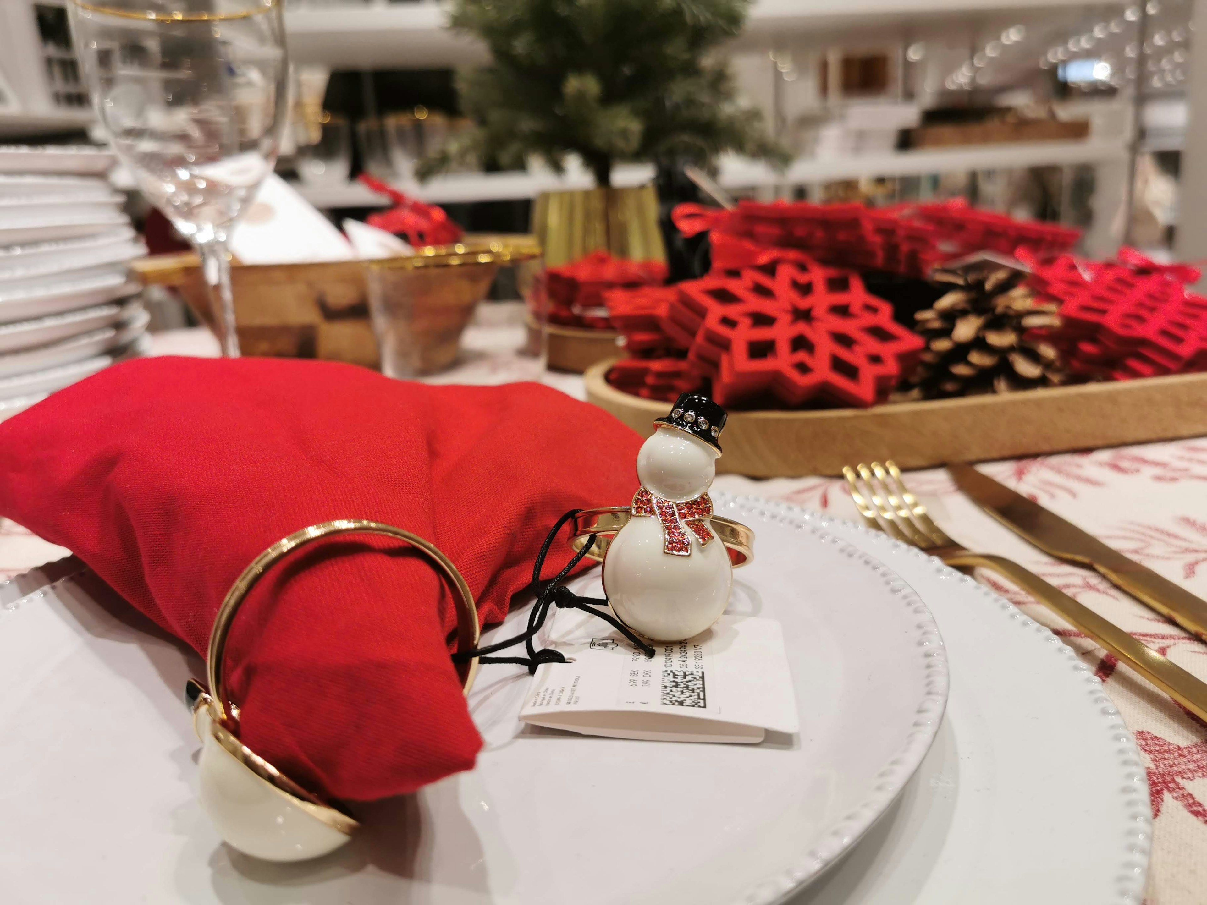 Christmas table setting featuring a red pouch and a snowman decoration