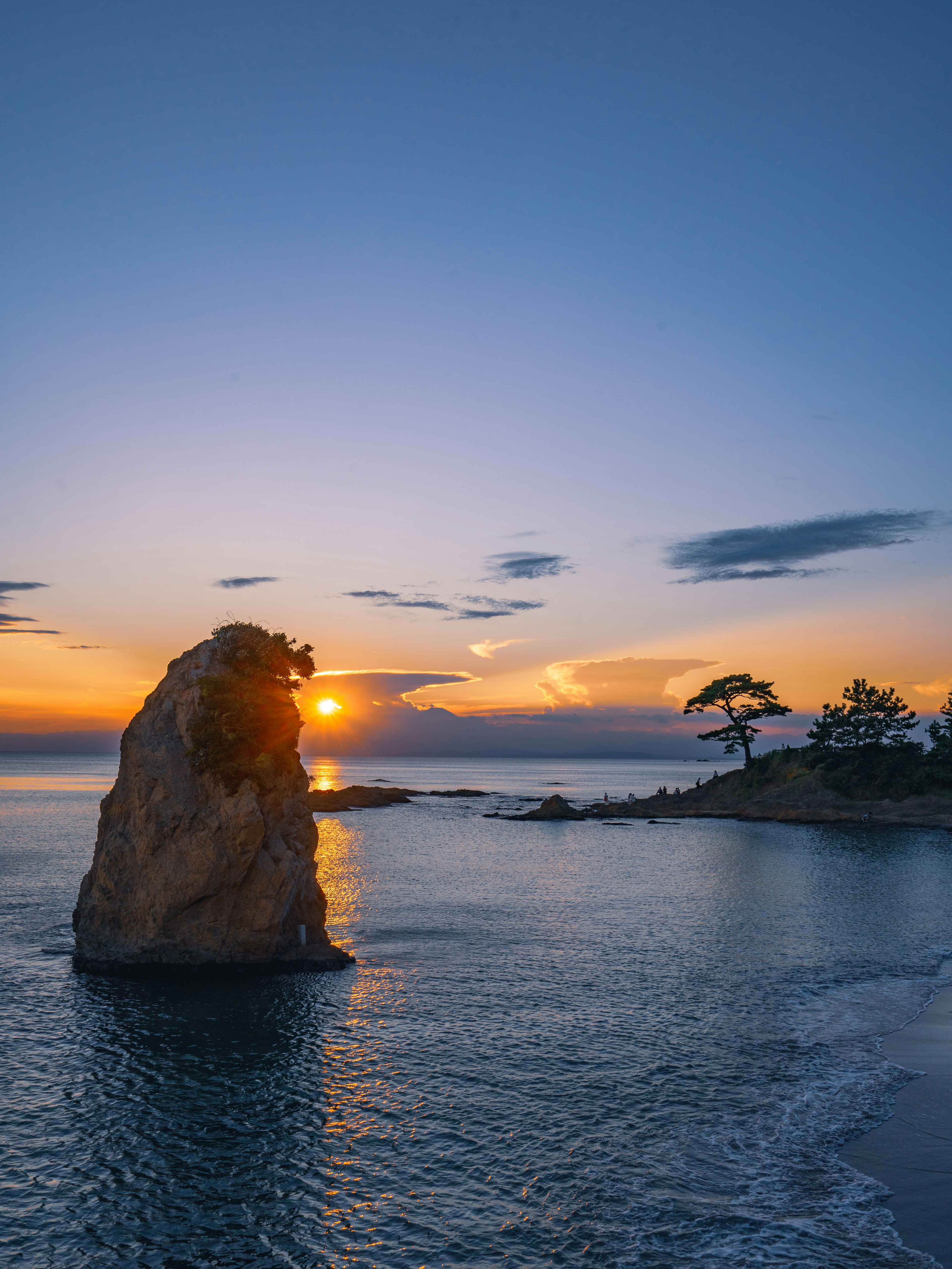 Bellissimo paesaggio con tramonto sull'oceano grande roccia e acqua calma