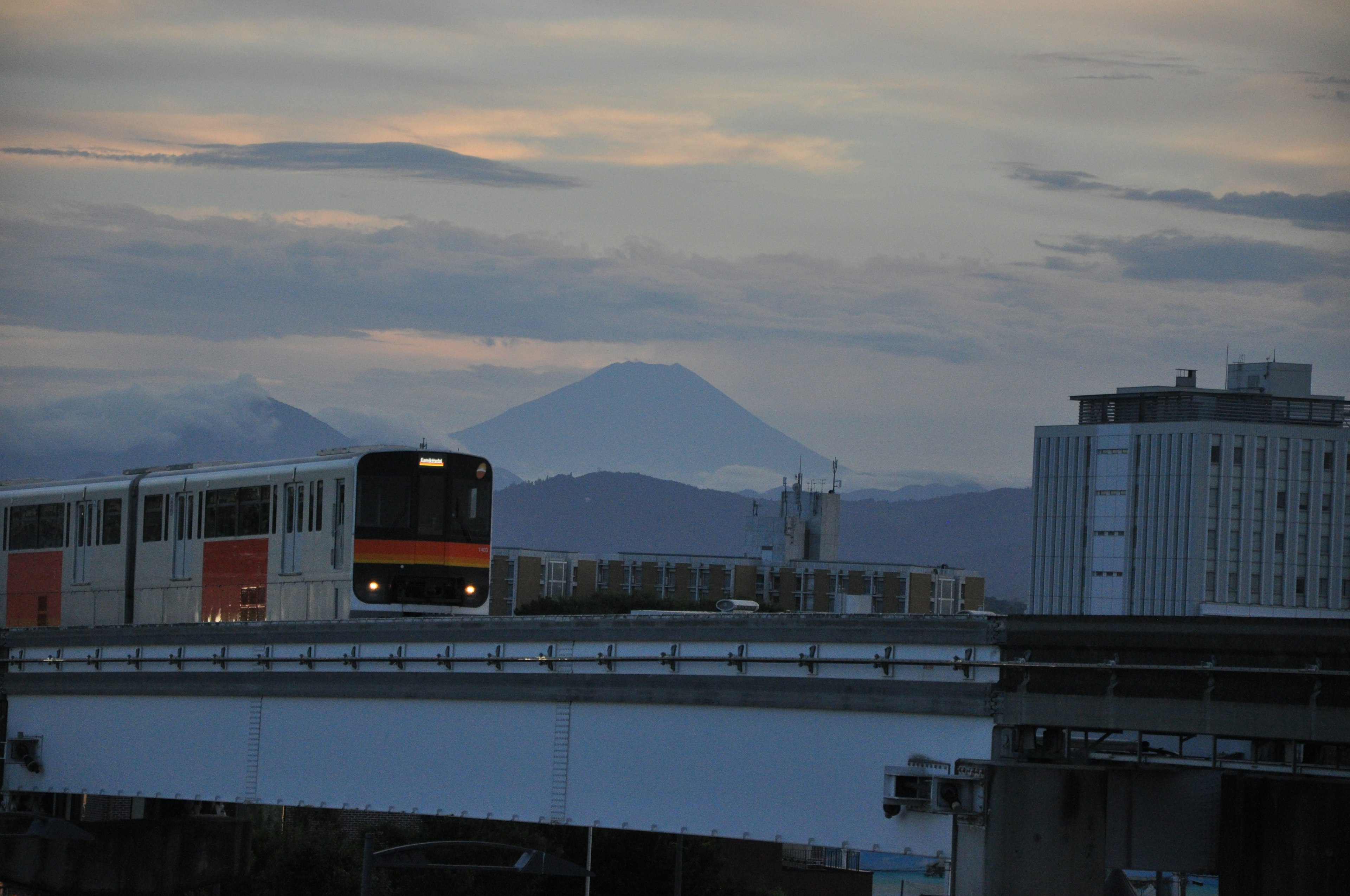 Train running in the evening with Mount Fuji in the background