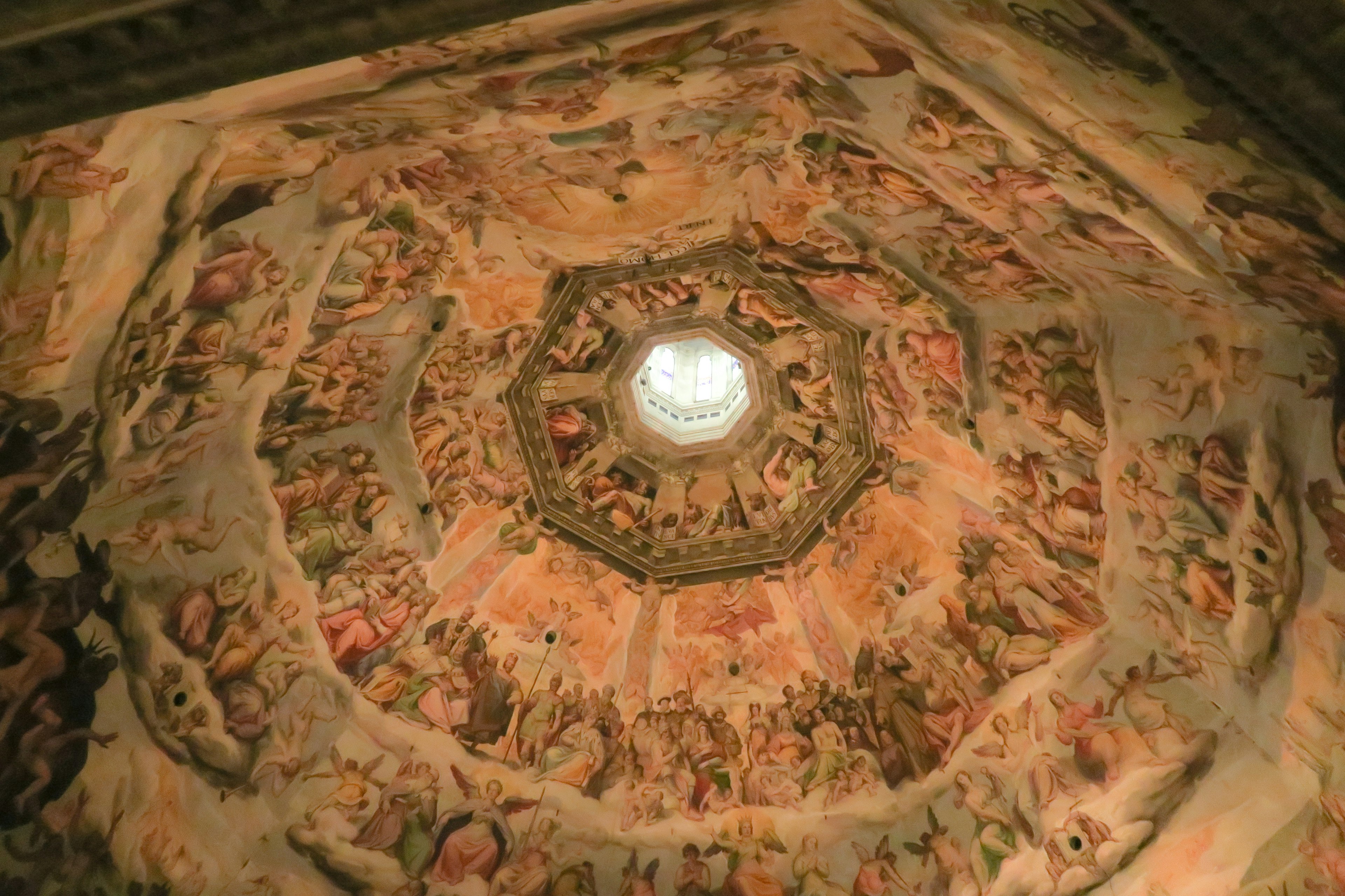 Intricate octagonal dome ceiling featuring vibrant frescoes illuminated by central light