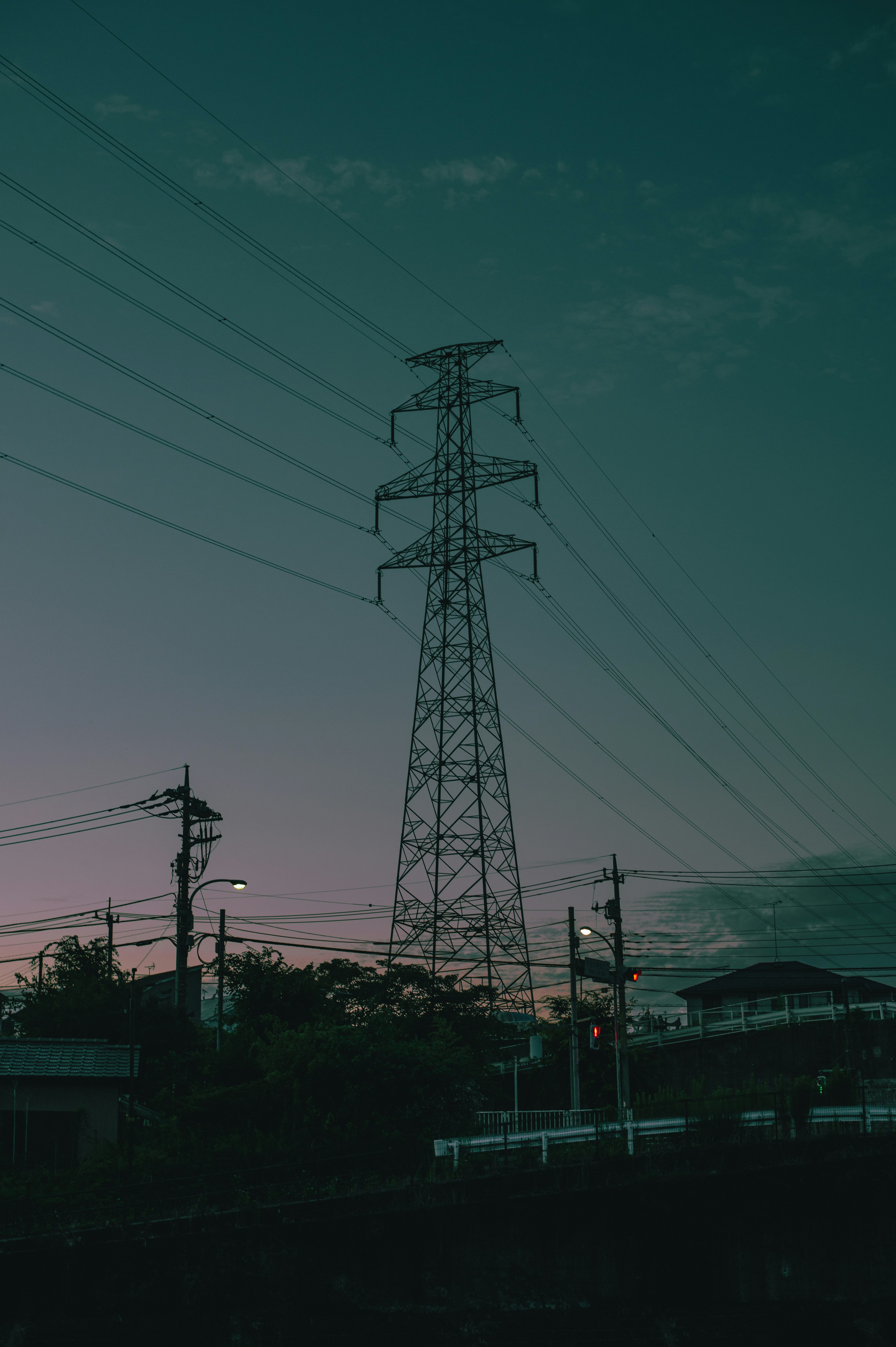 Silhouette de un poste de luz y líneas eléctricas al anochecer