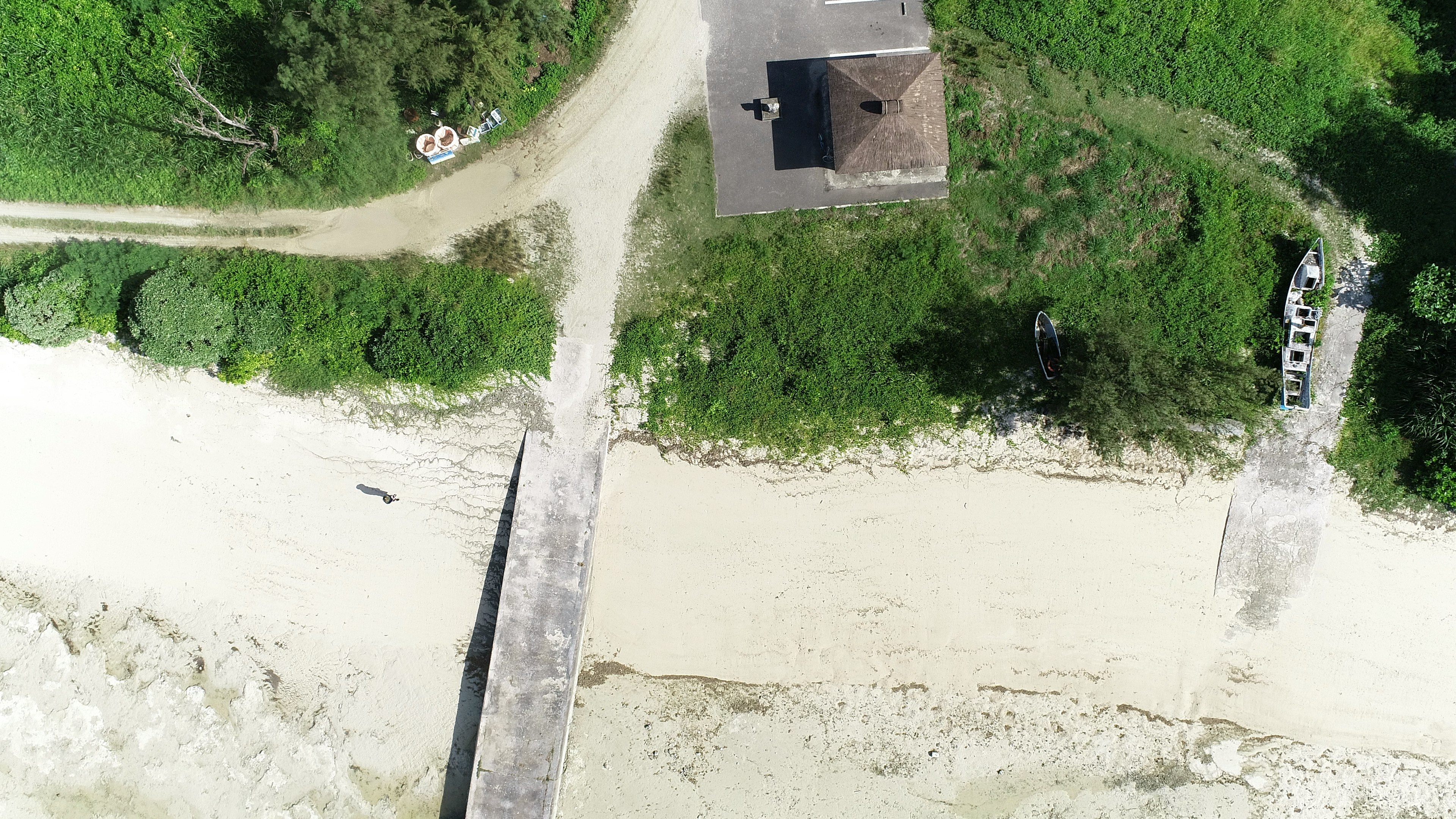 Vista aerea di una spiaggia con una piccola casa e un ponte