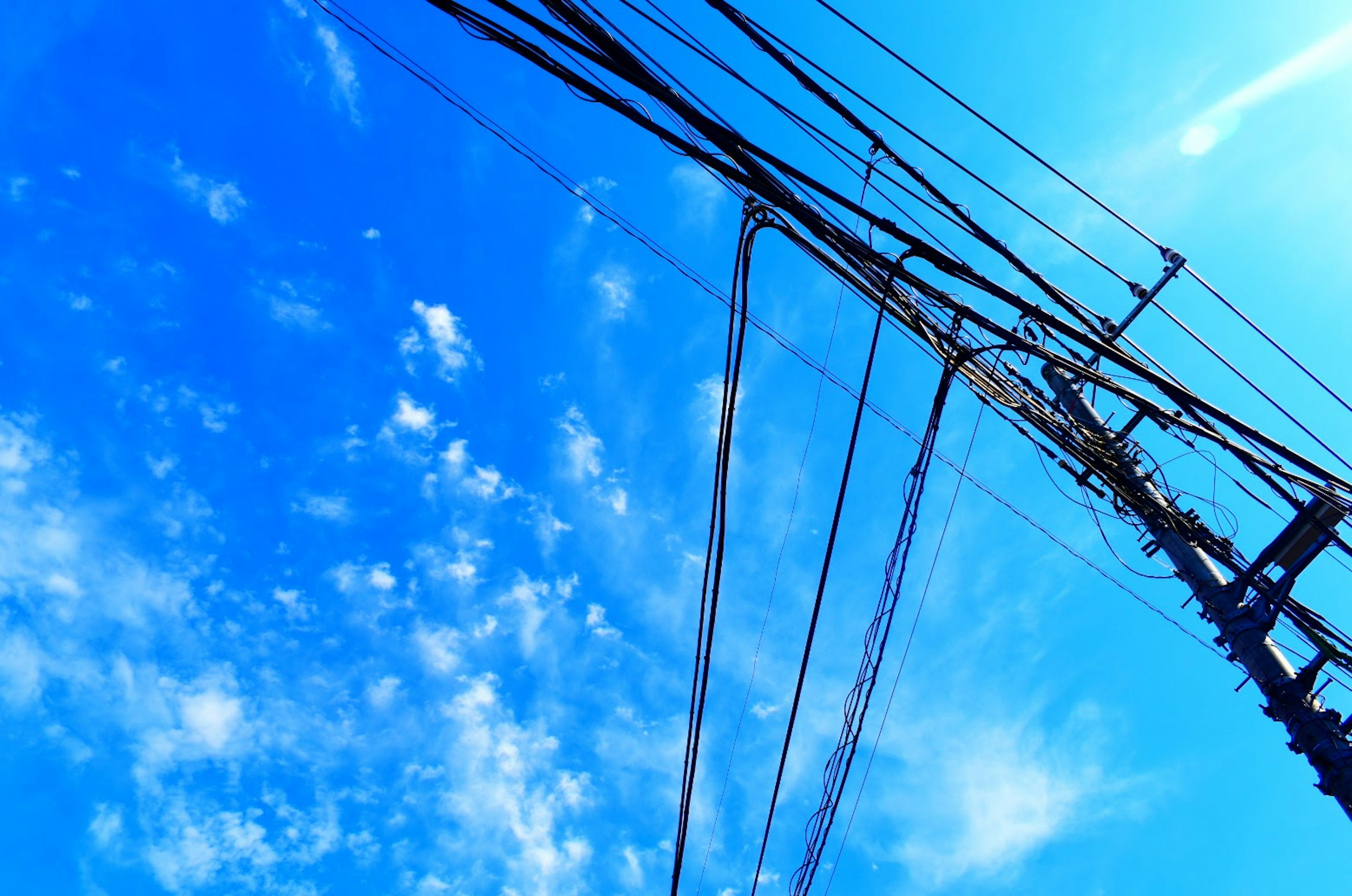 Pemandangan langit biru yang disilangkan oleh kabel listrik