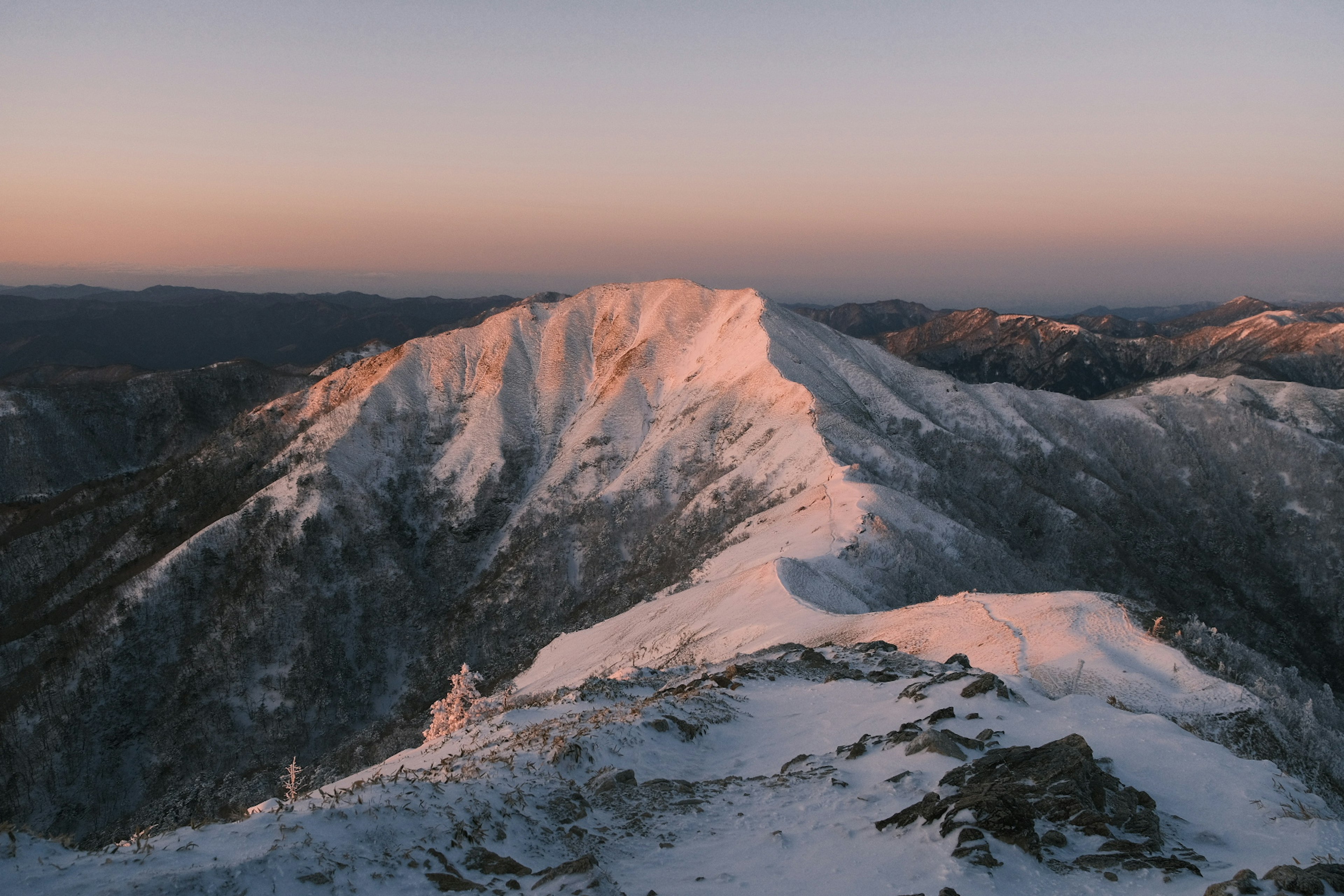 雪に覆われた山の頂上と夕焼けの空