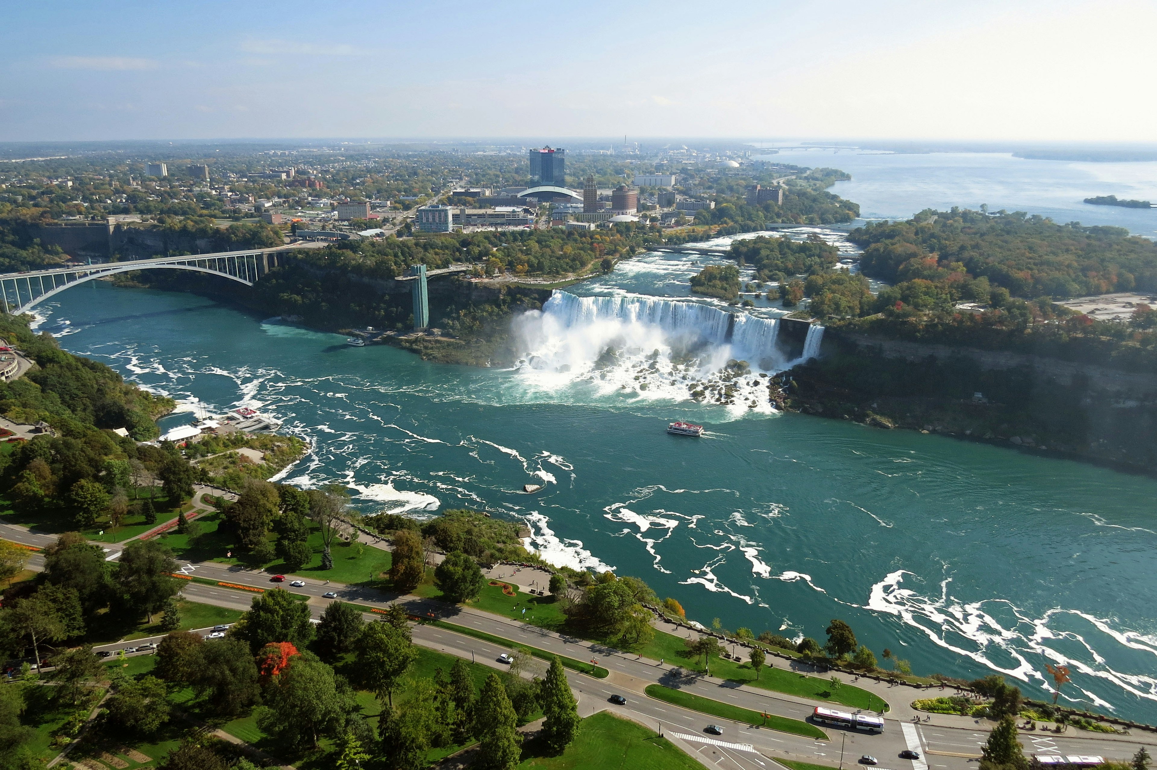 Aerial view of Niagara Falls featuring vibrant blue waters and lush greenery