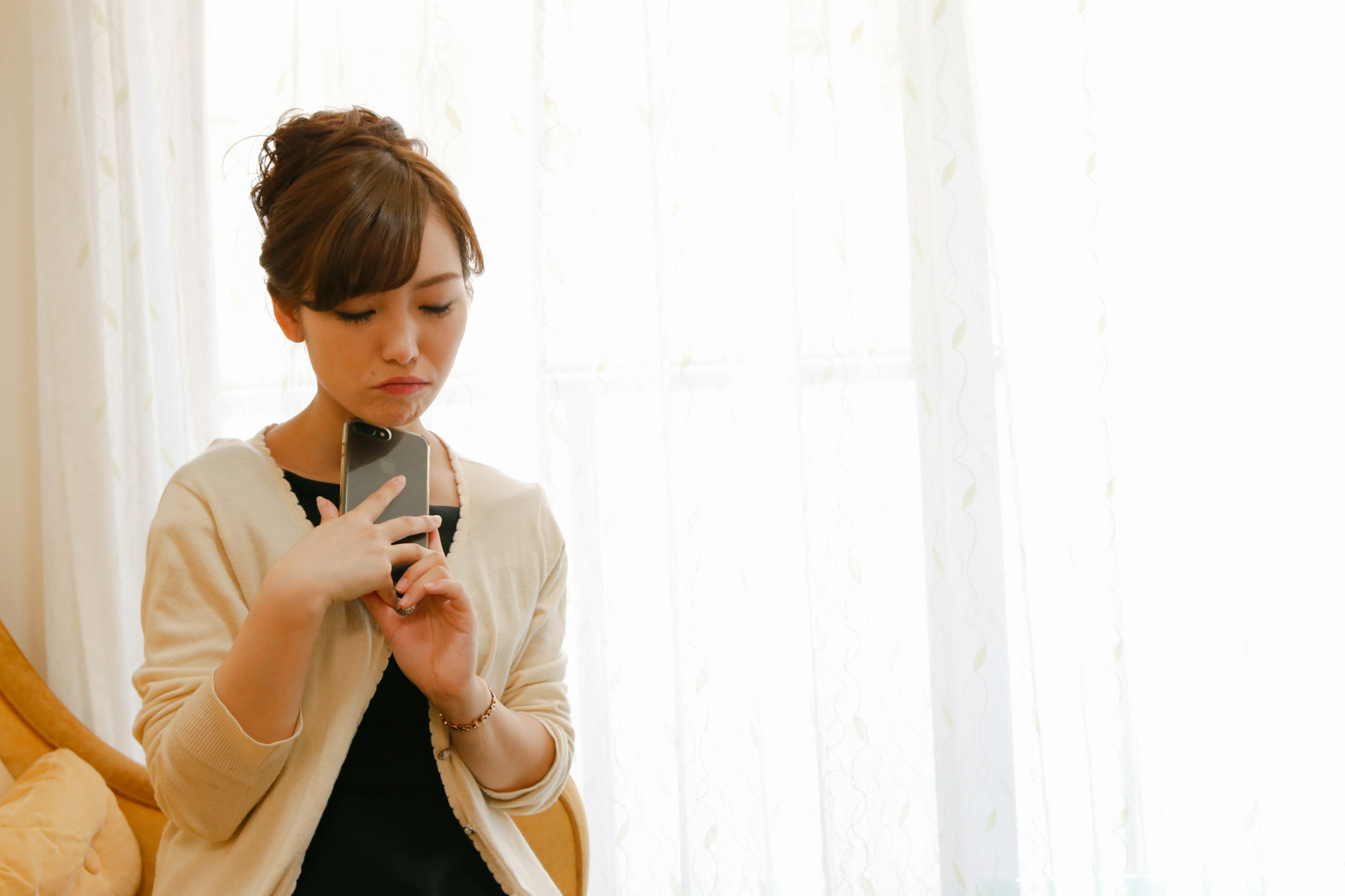 Portrait of a woman holding a smartphone by the window