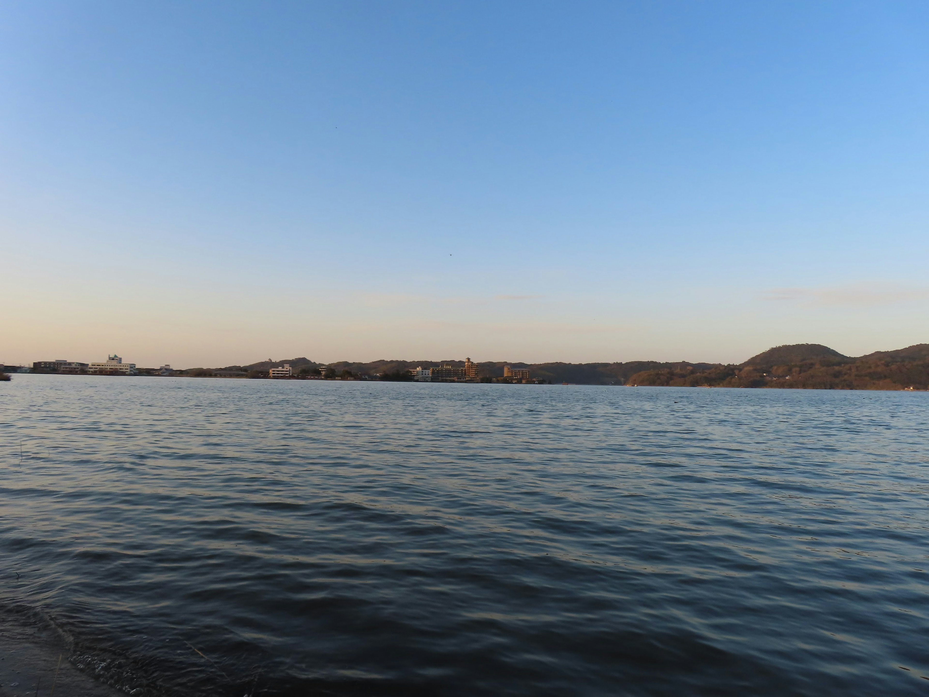 Superficie de agua tranquila con cielo azul claro