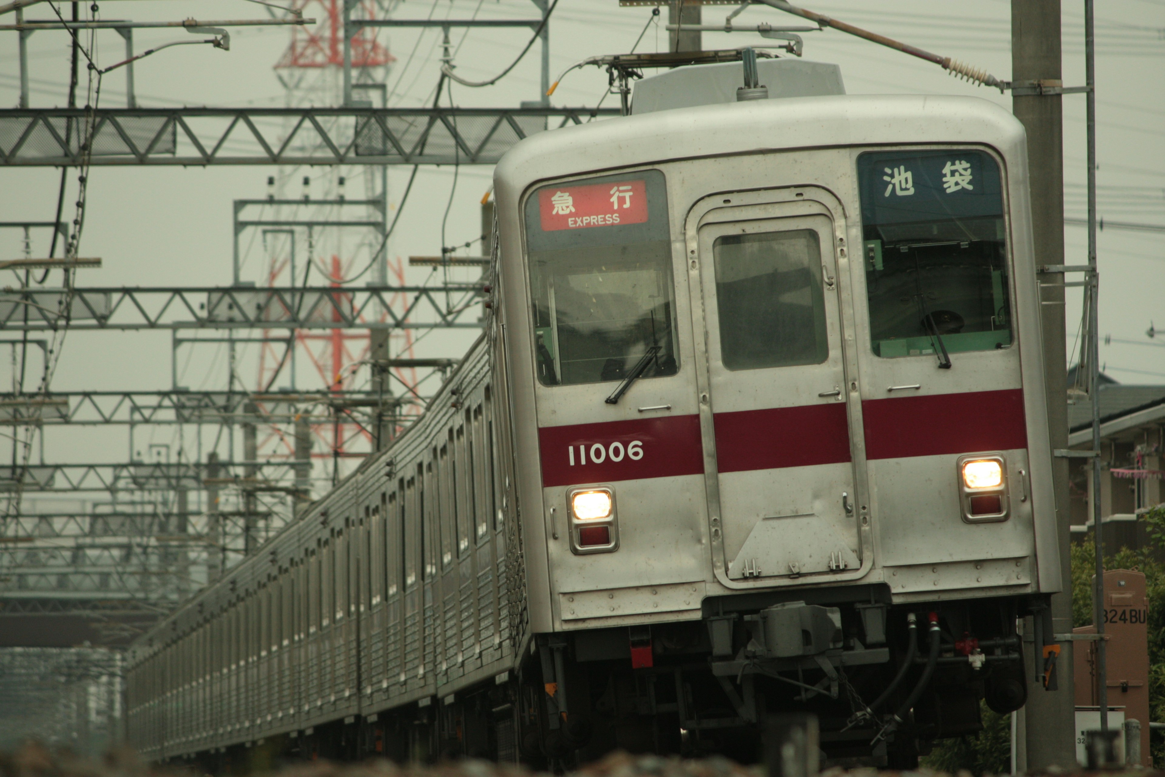 Un treno con una striscia rossa corre sui binari