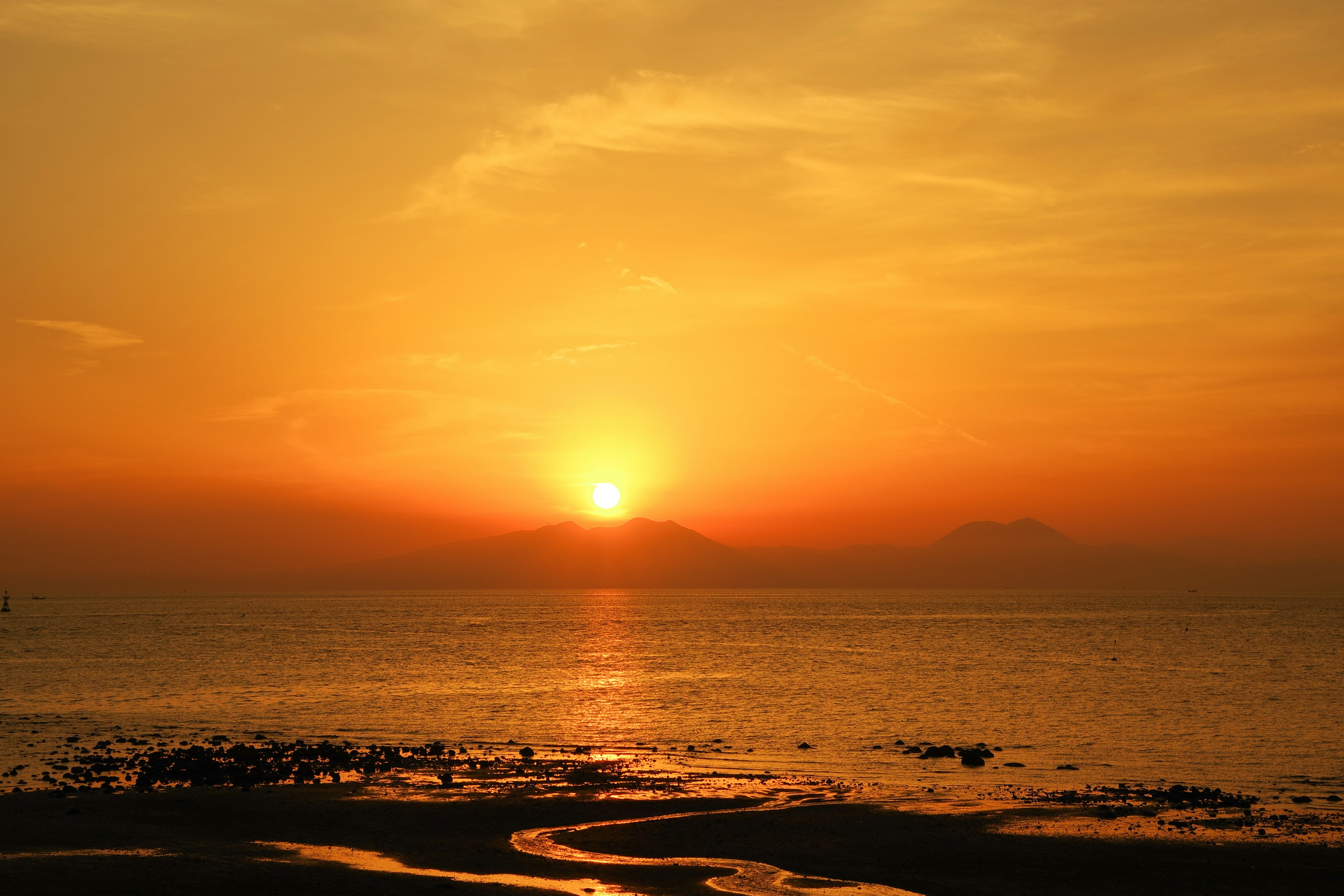 Wunderschöner orangefarbener Sonnenuntergang, der sich im Meer spiegelt