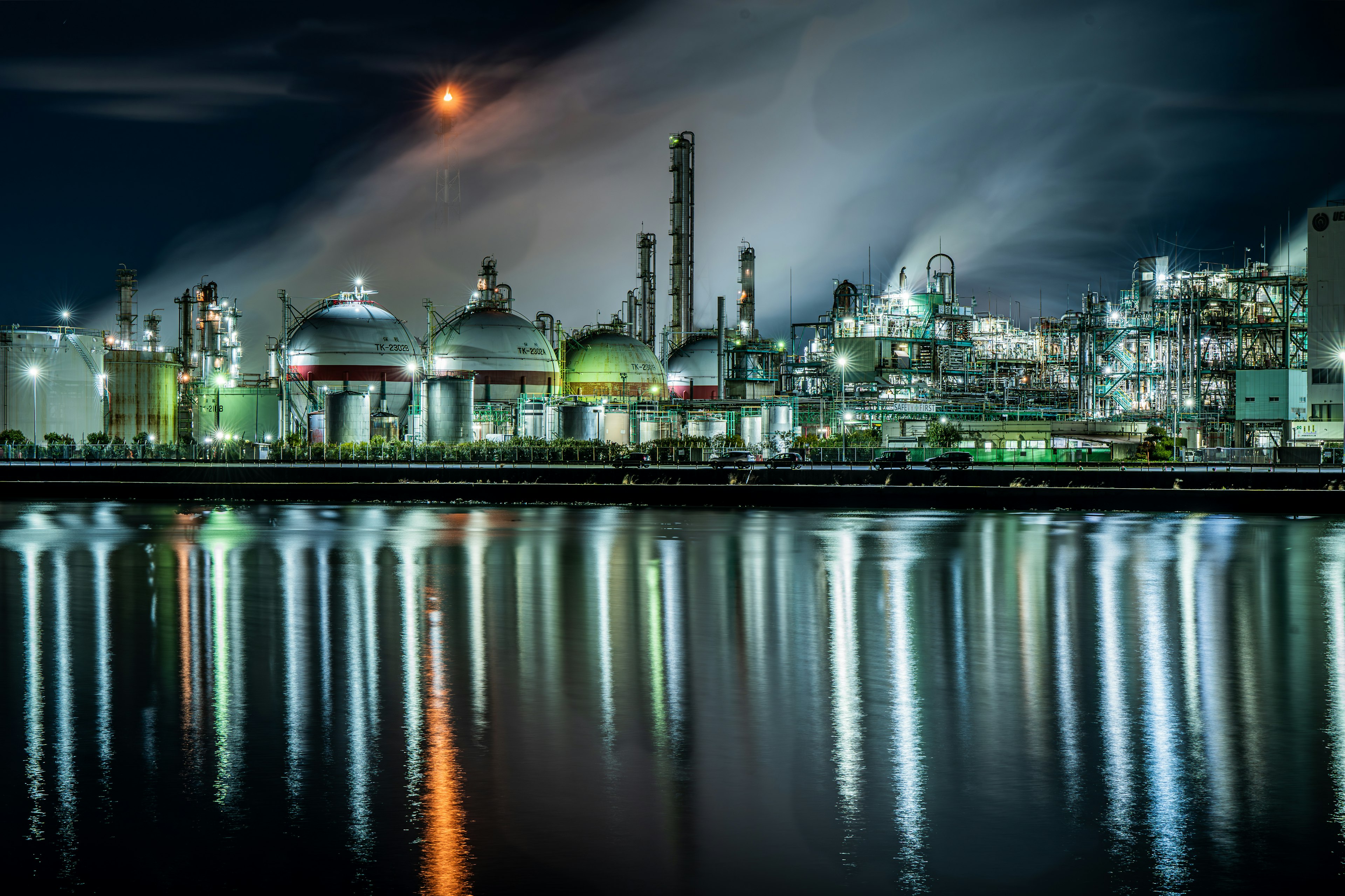 Paisaje industrial nocturno con luces y reflejos humo y luz de luna