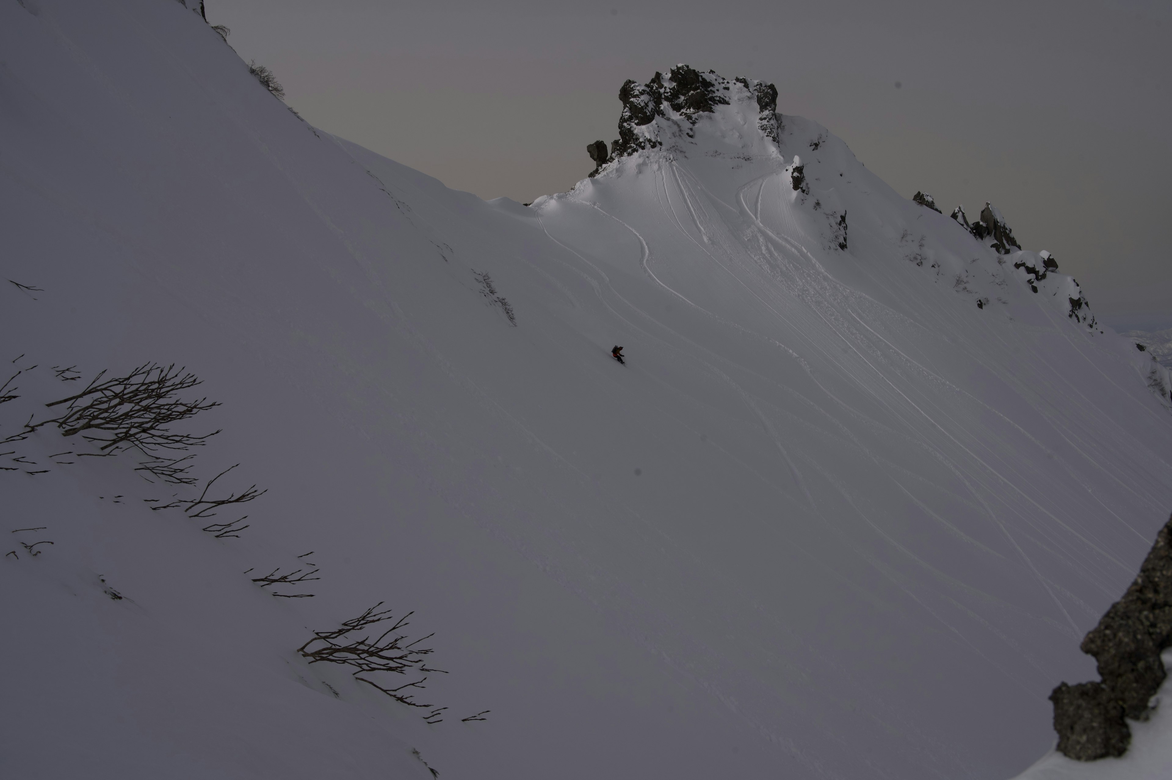 Pente de montagne enneigée avec un rocher saillant