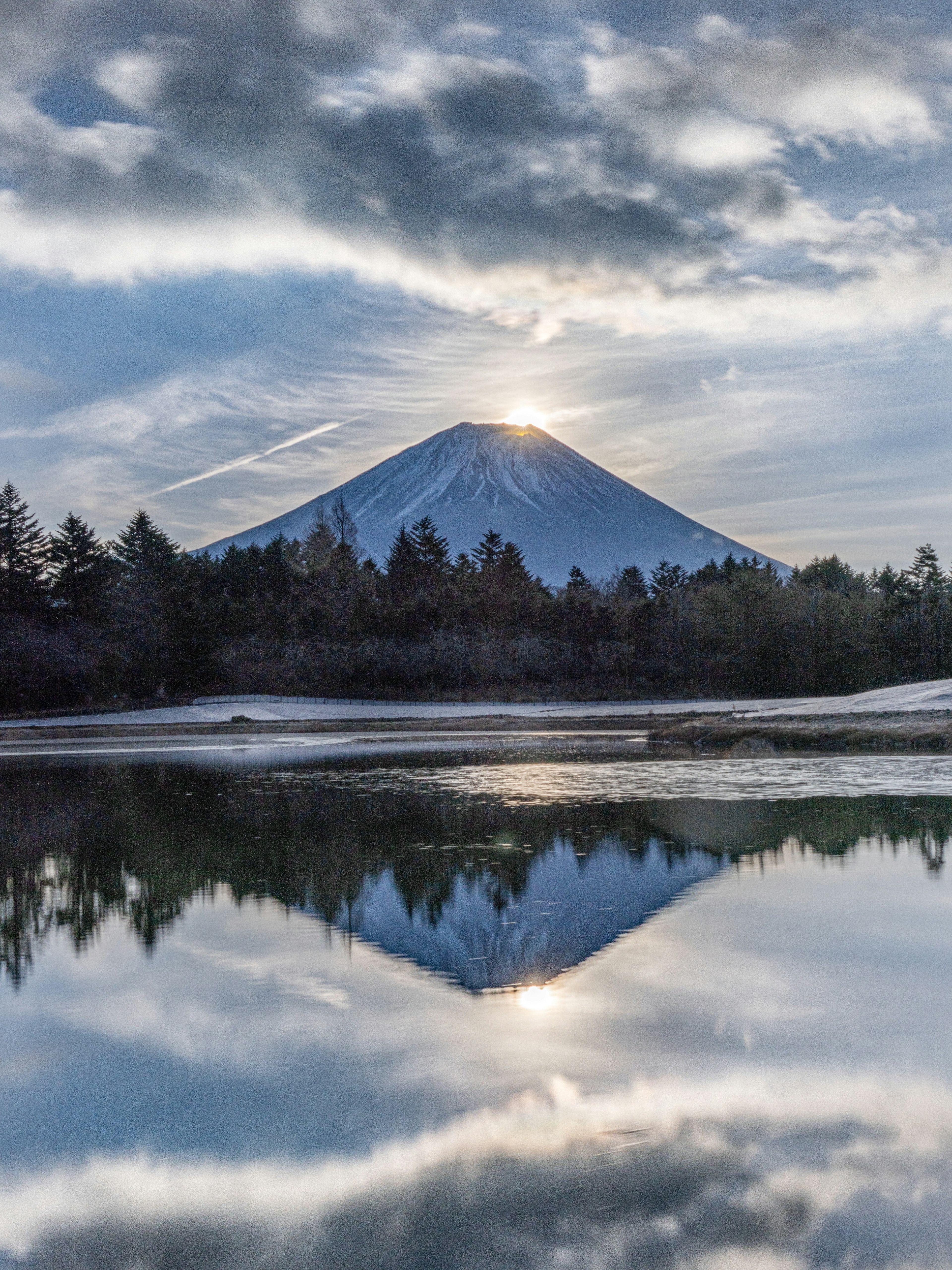 Un paysage serein avec le reflet du mont Fuji sur une surface d'eau calme