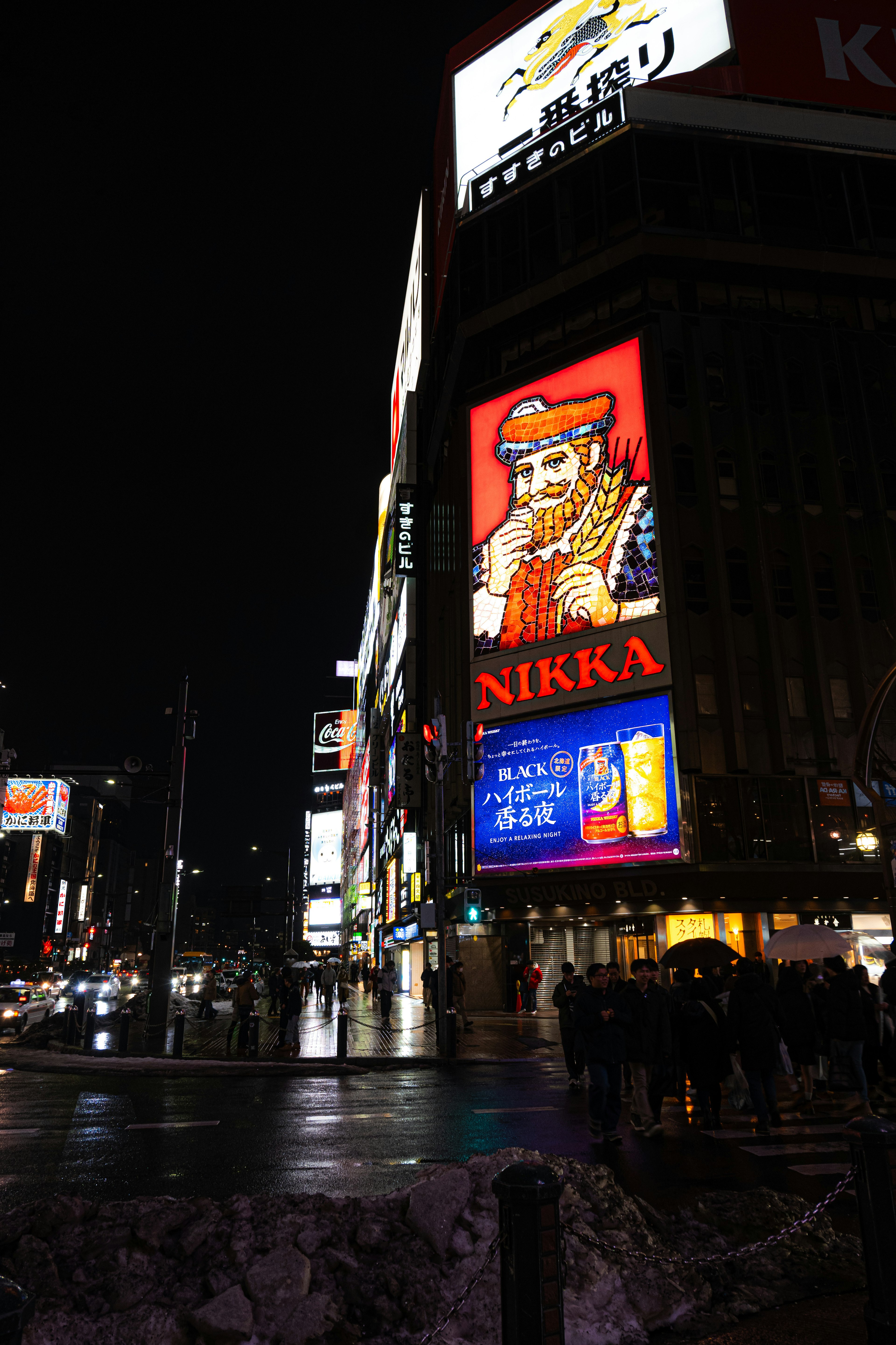 Cartel iluminado de Nikka Whiskey en una escena nocturna bulliciosa