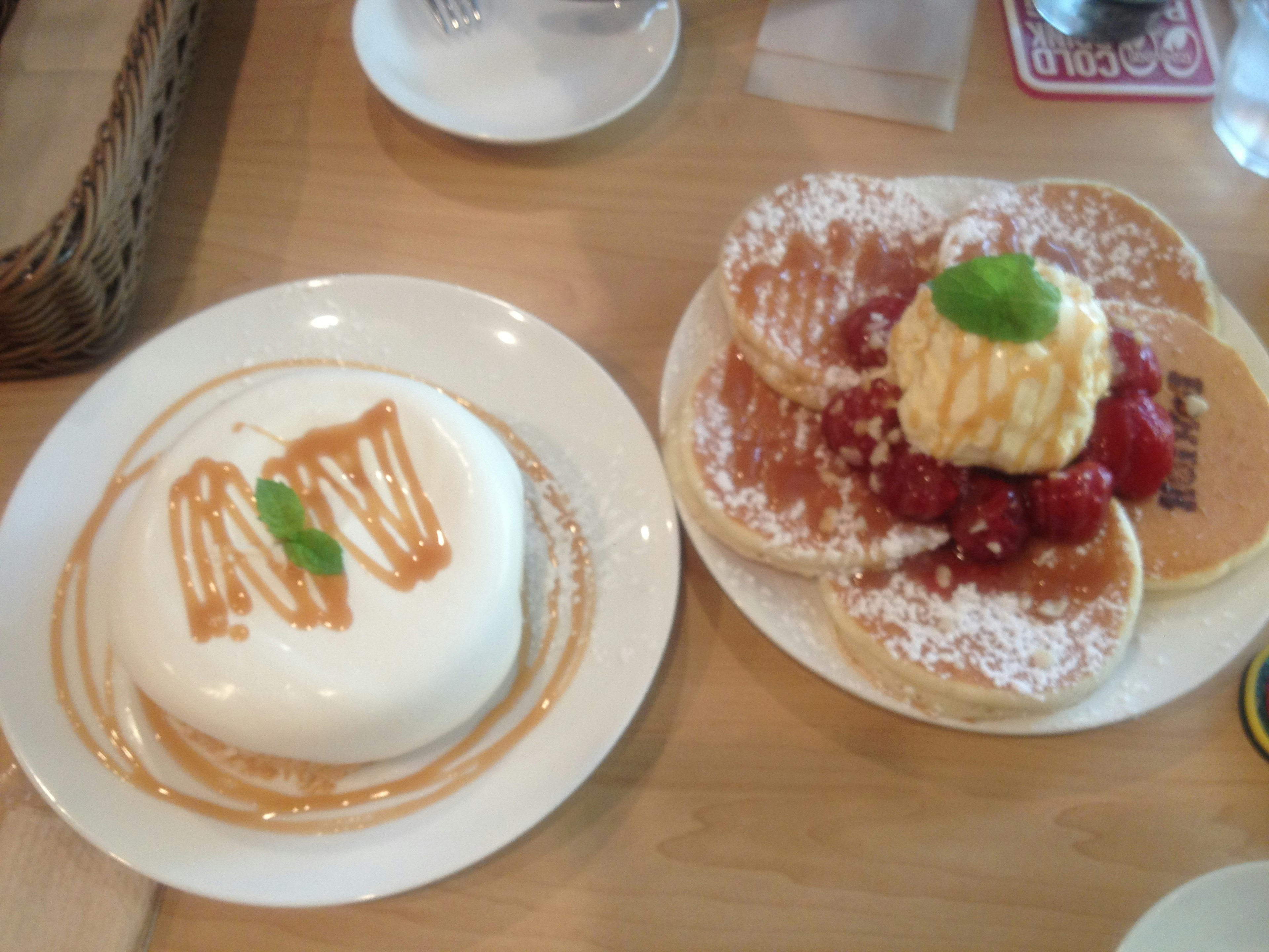 Dessert plate featuring a cream cake and pancakes topped with ice cream and raspberries