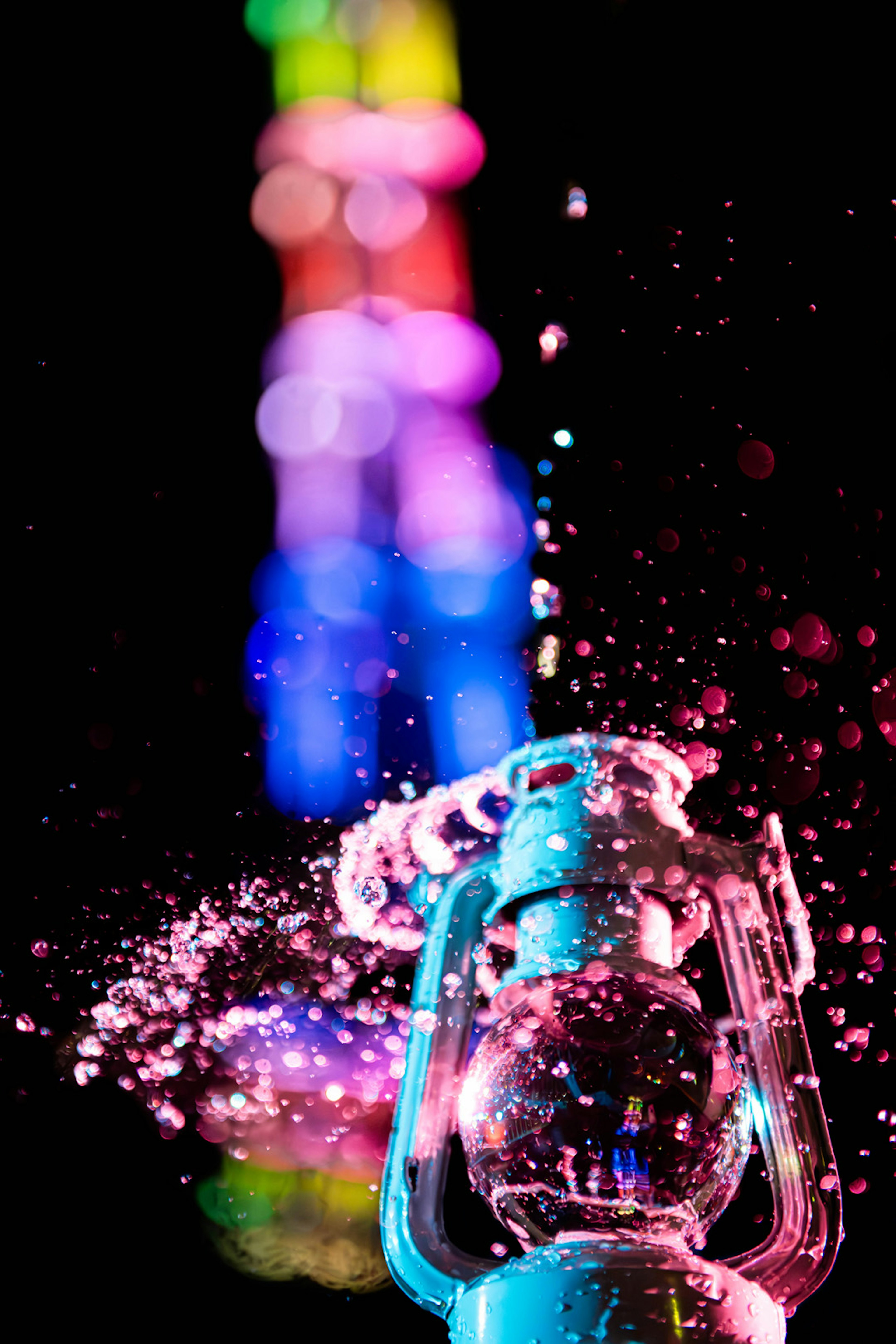 Fountain splashing water with colorful lights in the background